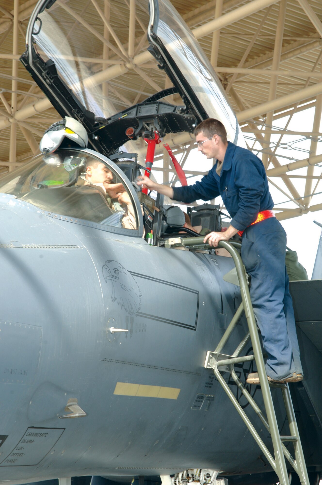 Airman 1st Class Benny Rutledge, 379th Expeditionary Maintenance Squadron crew chief, assists a 494th Expeditionary Fighter Squadron pilot with his safety equipment Friday.
