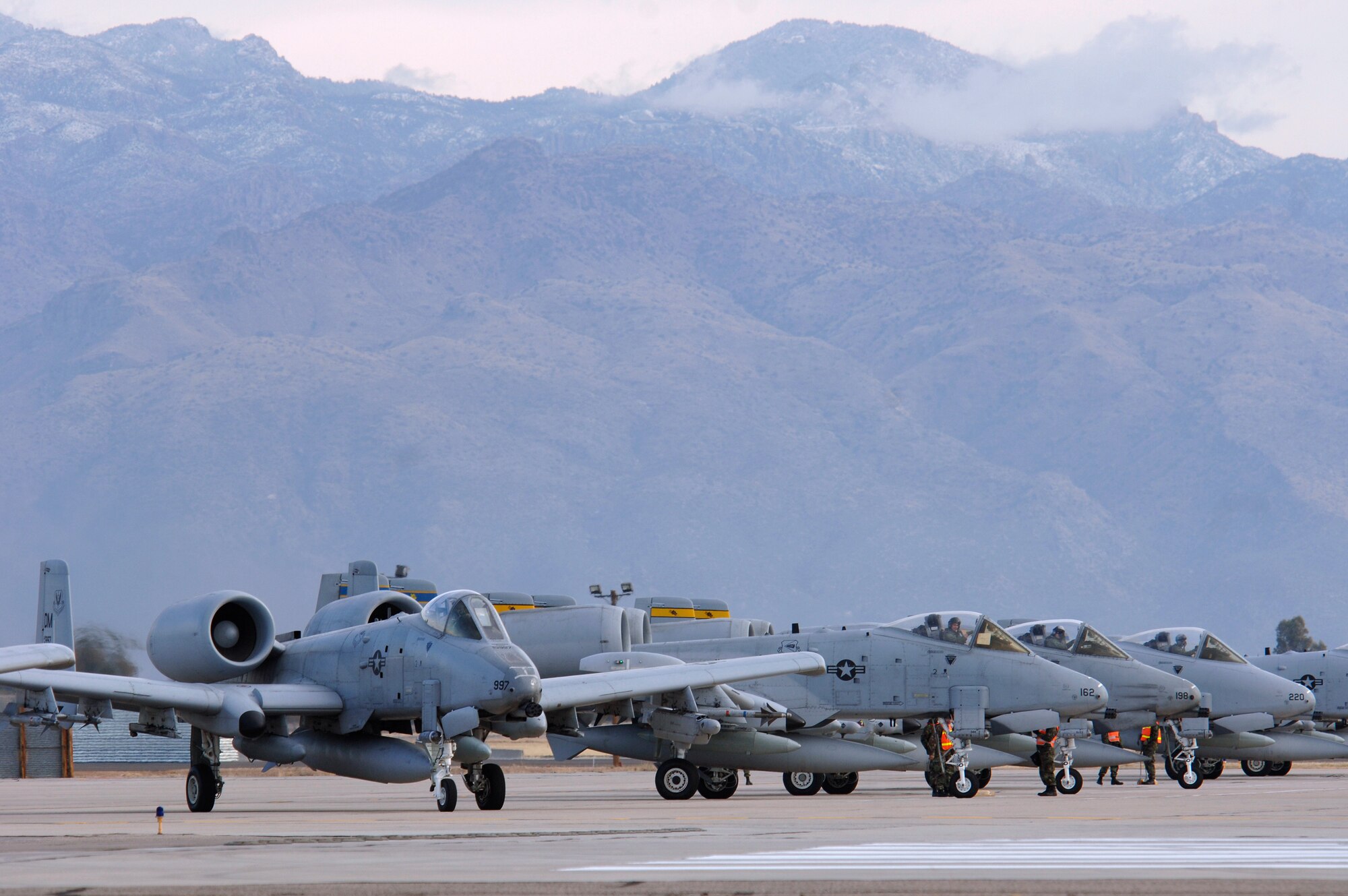 A-10 Thunderbolt IIs from the 354th Fighter Squadron sit on the end of the runway as they are armed by crew chiefs from the 355th Maintenance Squadron as they prepare to take off to a simulated location as part of Exercise Bushwacker 07-02 Jan. 21 from Davis-Monthan Air Force Base, Ariz. Bushwacker 07-02 is an operational readiness exercise designed to prepare the 355th Wing for deployment. (U.S. Air Force photo/Senior Airman Christina D. Ponte)