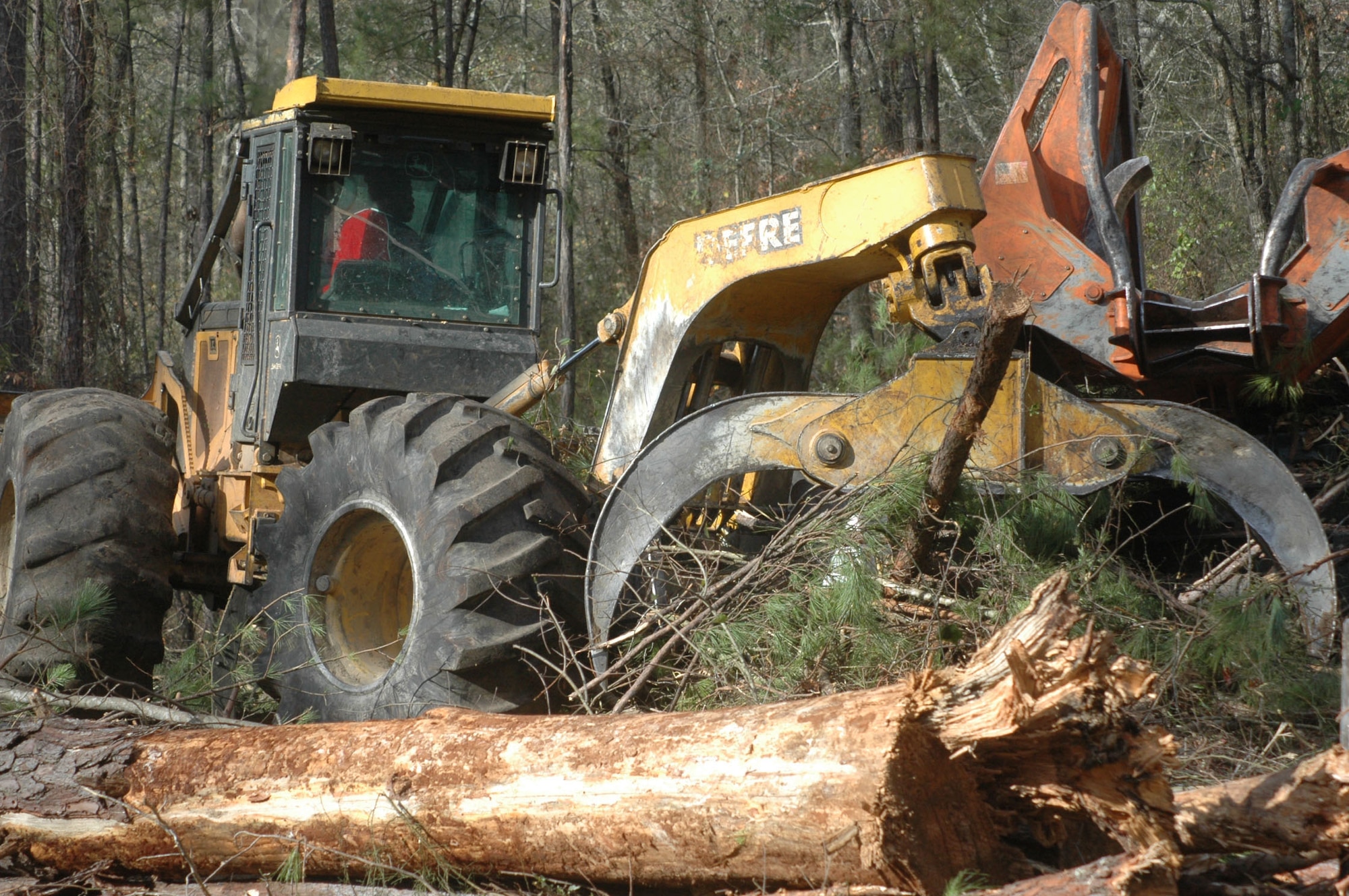 An area on the south end of Robins Air Force Base is designated as a Longleaf pine reforestation site. A skidder drags downed trees to be loaded and picks up debris. (U.S. Air Force photo by Sue Sapp)
