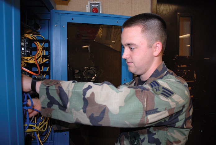 Senior Airman Brian Decker, 437th Communications Squadron network maintenance technician, connects cables to the information transfer node at the Information Systems Flight building recently. (U.S. Air Force photo by Senior Airman Sam Hymas)