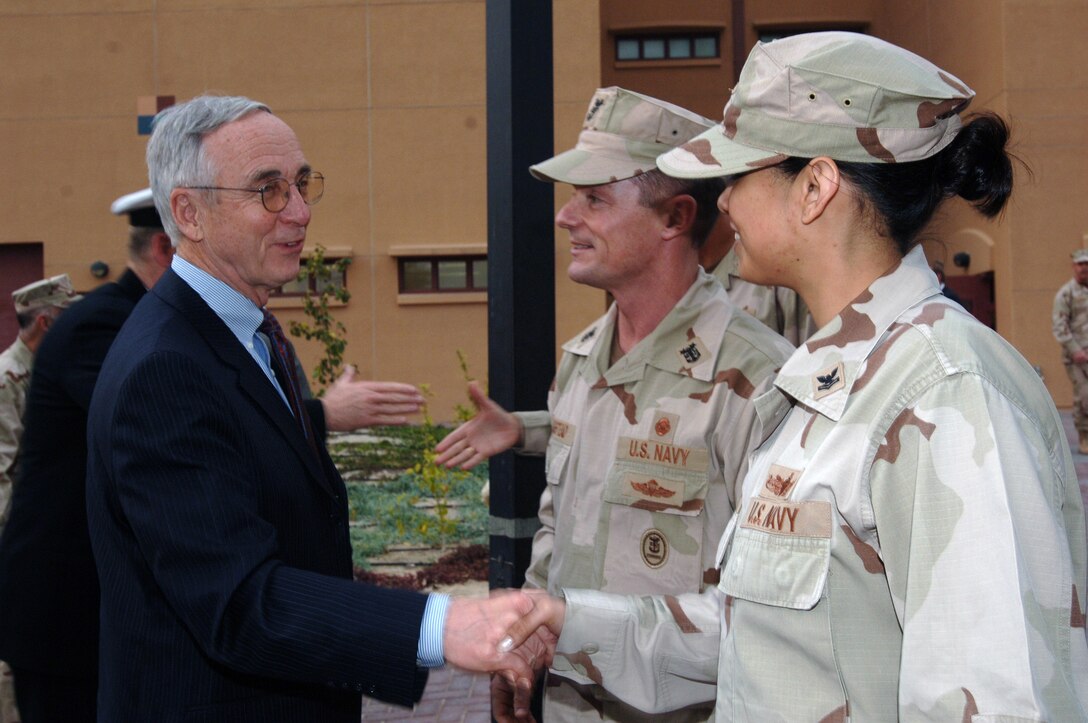Deputy Defense Secretary Gordon England greets the U.S. Naval Forces Central Command junior sailor of the year, Petty Officer 2nd Class Teresa Charvira, and NAVCENT Command Master Chief Petty Officer Christopher Angstead (center) before conducting a town hall meeting for servicemembers at Naval Support Activity Bahrain. England thanked the audience for their dedicated service. Photo by Chief Petty Officer Julian Carroll, USN