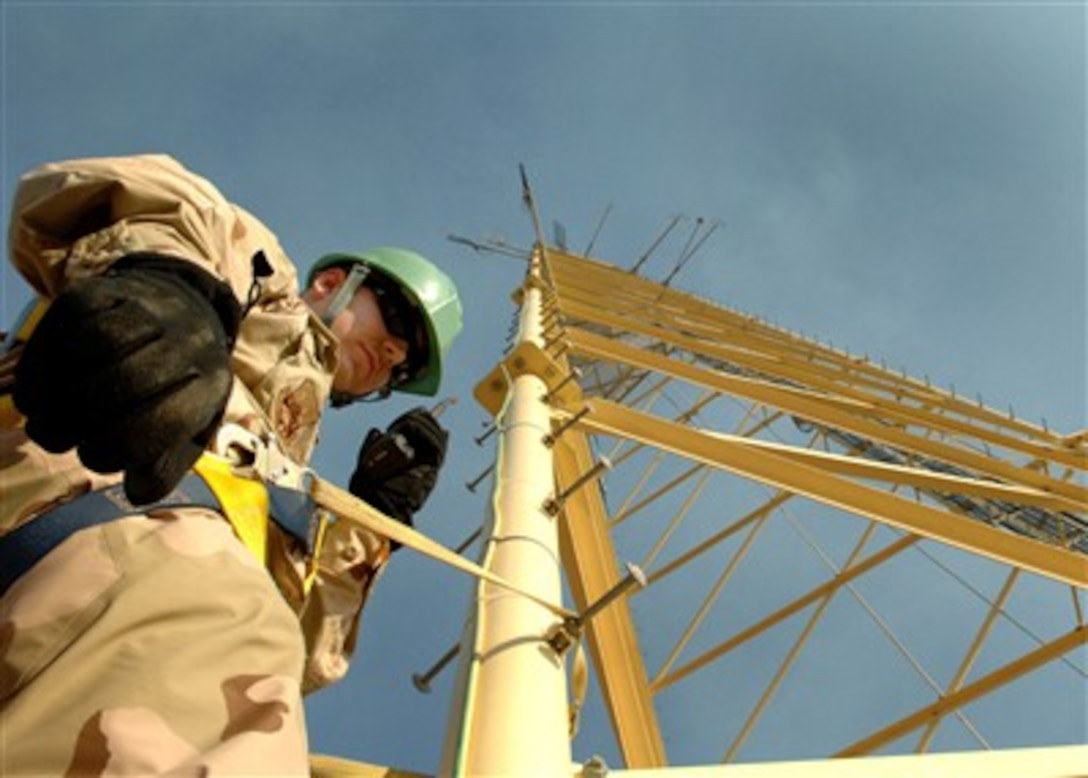 Air Force Senior Airman Darren McGee climbs a 170 ft. radio antenna tower on Balad Air Base, Iraq, during annual climber certification training on Jan. 15, 2007. McGee is a satellite communication journeyman with the 332nd Expeditionary Communications Squadron.  