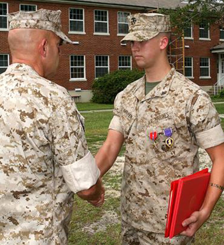 MARINE CORPS BASE CAMP LEJEUNE, N.C. -- Lance Cpl. Albert R. Harper, a vehicle operator with 3rd Battalion, 6th Marine Regiment, 2nd Marine Division, shakes hands with Brig. Gen. David H. Berger, the assistant division commander of 2nd Marine Division, after receiving the Bronze Star Medal with a combat distinguishing device and Purple Heart Medal at a ceremony here Aug. 23. Harper was awarded the Bronze Star Medal for heroism and courageous actions while conducting combat operations in support of Operation Iraqi Freedom. He received the Purple Heart Medal for wounds sustained Feb. 16, 2007.