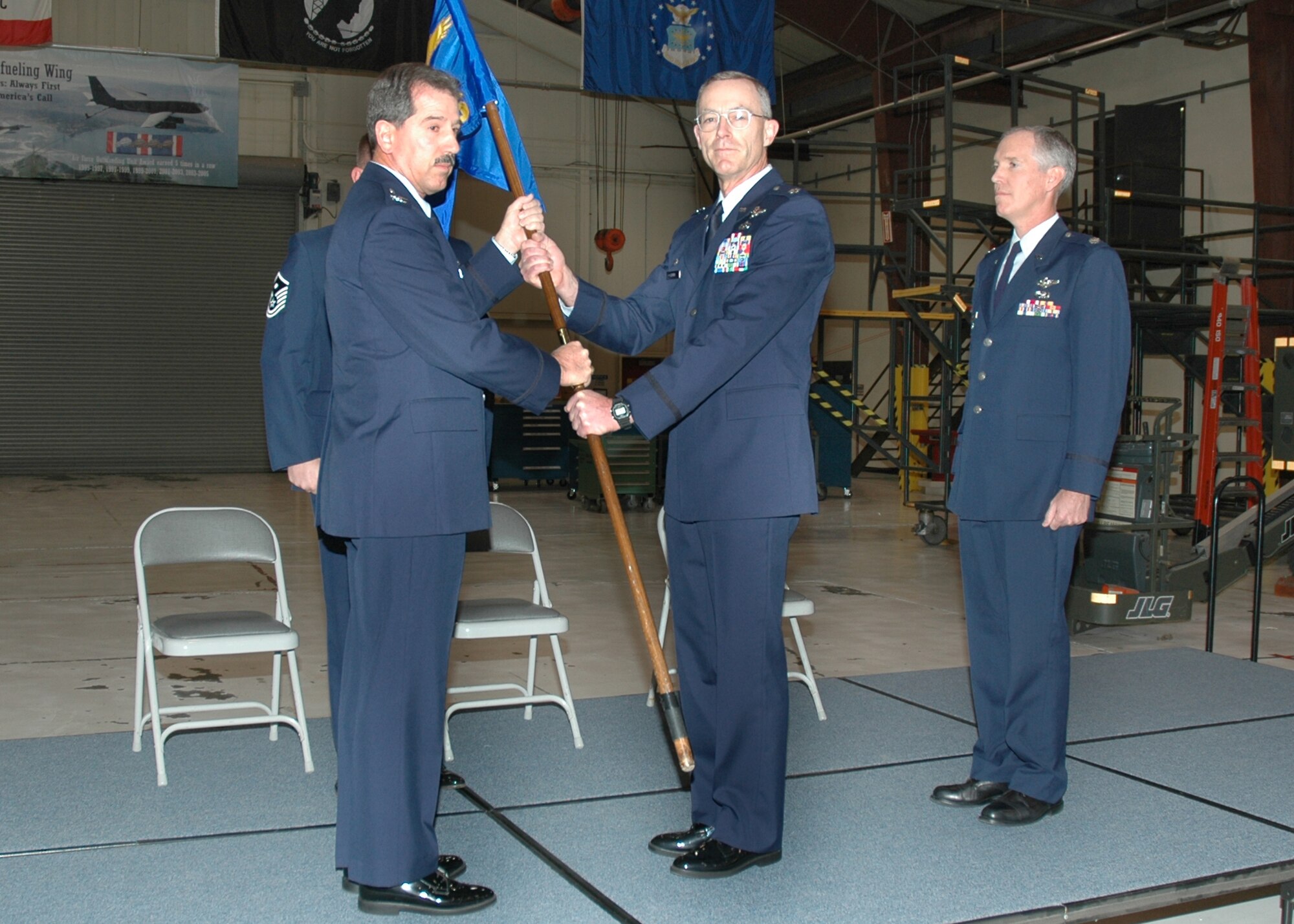 Air Force Reservist Col. Melvin "Sonny" Giddings, 940th Maintenance Group commander, accepts the Aircraft Maintenance Squadron flag from the outgoing squadron commander, Lt. Col. Gregory Steuer, while Lt. Col. Robert Dunn waits to take the flag and command of the unit during a ceremony Jan. 7, 2007 at Beale Air Force Base, Calif. Colonel Steuer is leaving the unit for a promotion with Fourth Air Force at March Air Reserve Base, Calif. (U.S. Air Force photo/Master Sgt. Ellen Hatfield Wilt)