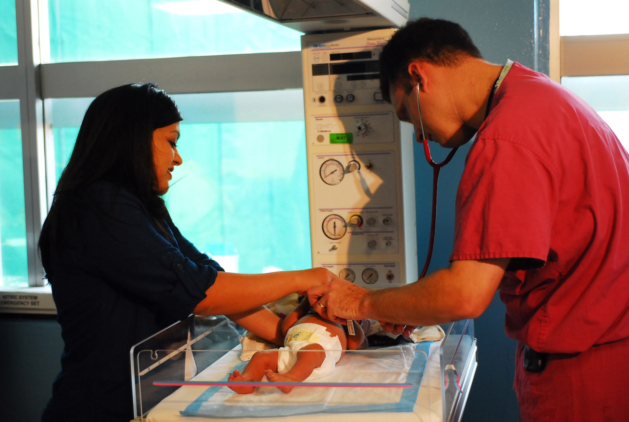 Mari Nash helps Maj. (Dr.) Jay Kerecman checks her daughter, Mia, after she was hospitalized for a blood disorder immediately after birth. Baby Mia made a full recovery after receiving care from the Neonatal Intensive Care Unit staff. Ms. Nash is the wife of Lt. Col. Christopher Nash of the 3rd Marine Expeditionary Forces, and Major Kerecman is an 18th Medical Operations Squadron NICU staff neonatologist. (U.S. Air Force photo/Airman Gary Edwards)
