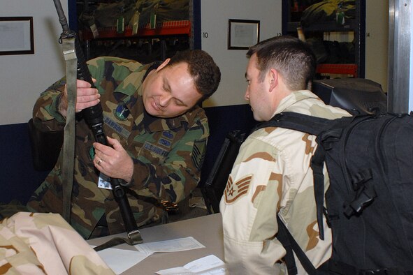 Master Sgt. James Dawson, 314th Logistics Readiness Squadron, prepares an M-16 before issuing it to Staff Sgt. Nicholas Noonan, 314th LRS, at Little Rock Air Force Base Jan. 21.The deploying troops were given a final farewell by Brig. Gen. Kip Self, 314th Airlift Wing commander, before deploying to the area of responsibility. (Photo by Airman 1st Class Nathan Allen)