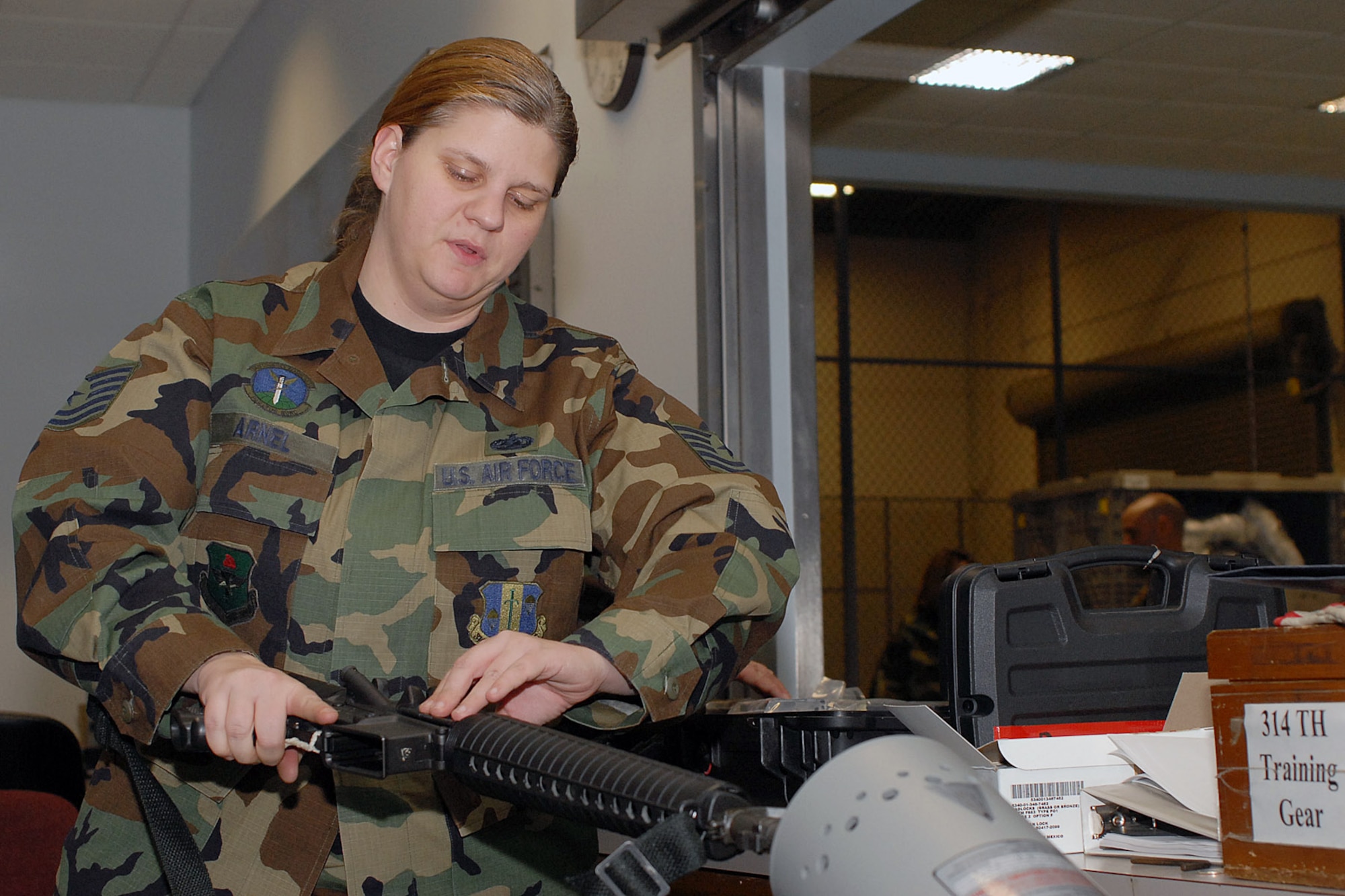 Tech. Sgt. Erin Arnel, 314th Logistics Readiness Squadron, clears an M-16 before issuing it to a deploying troop at Little Rock Air Force BaseJan. 21. The deploying troops were given a final farewell by Brig. Gen. Kip Self, 314th Airlift Wing commander before deploying to the area of responsibility. (Photo by Airman 1st Class Nathan Allen)