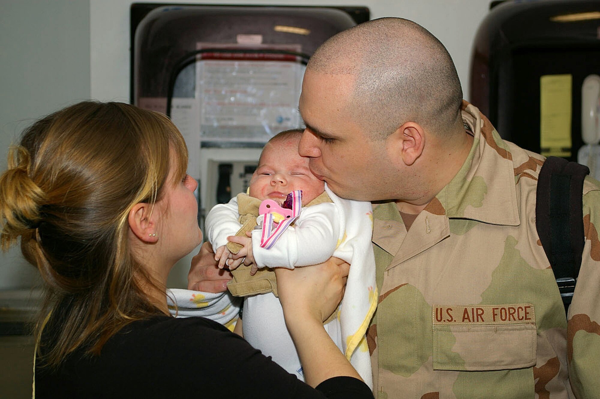 Senior Airman Michael Rios gives his 7-week-old daughter, Alleigh, and wife, Cristy, a kisses goodbye at the passenger terminal before leaving on a deployment to Southwest Asia Jan. 23 from Royal Air Force Mildenhall, England. Airman Cardenas is assigned to the 100th Civil Engineer Squadron. (U.S. Air Force photo/Karen Abeyasekere)
