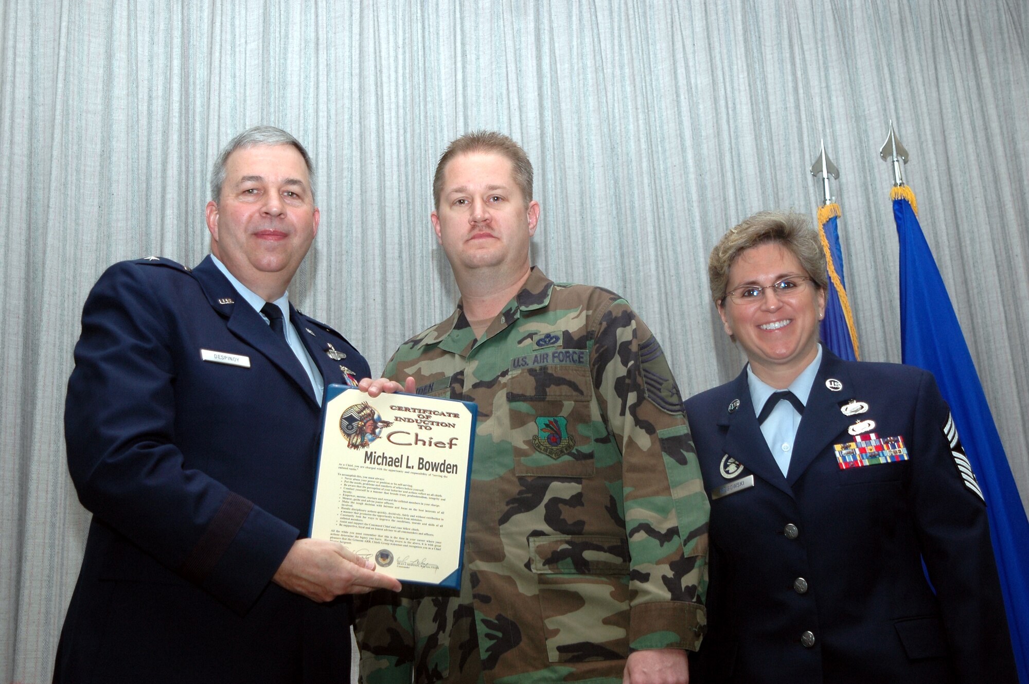 GRISSOM AIR RESERVE BASE, Ind., -- Brig. Gen. Dean Despinoy, 434th Air Refueling Wing commander, left, presents Chief Master Sgt. Michael Bowden, 434th Civil Engineering Squadron, a certificate upon his promotion to chief. Standing next to the new chief is Chief Master Sgt. Peri Rogowski, 434th ARW command chief. (U.S. Air Force photo/Senior Airman Chris Bolen)