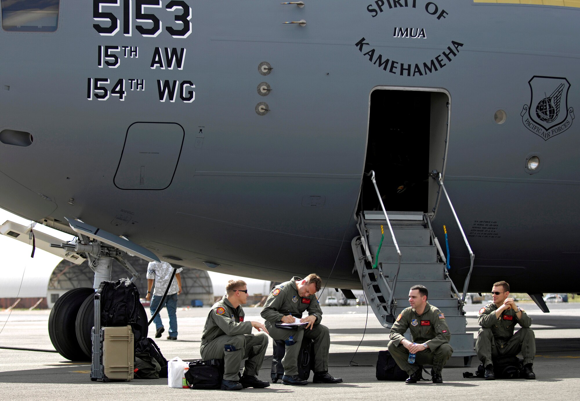 Pilots from the 535th Airlift Squadron from Hickam Air Force Base, Hawaii, wait for a crew bus Jan. 19 after returning from a local training mission over the Hawaiian Islands. (U.S. Air Force photo/Tech. Sgt. Shane A. Cuomo) 
