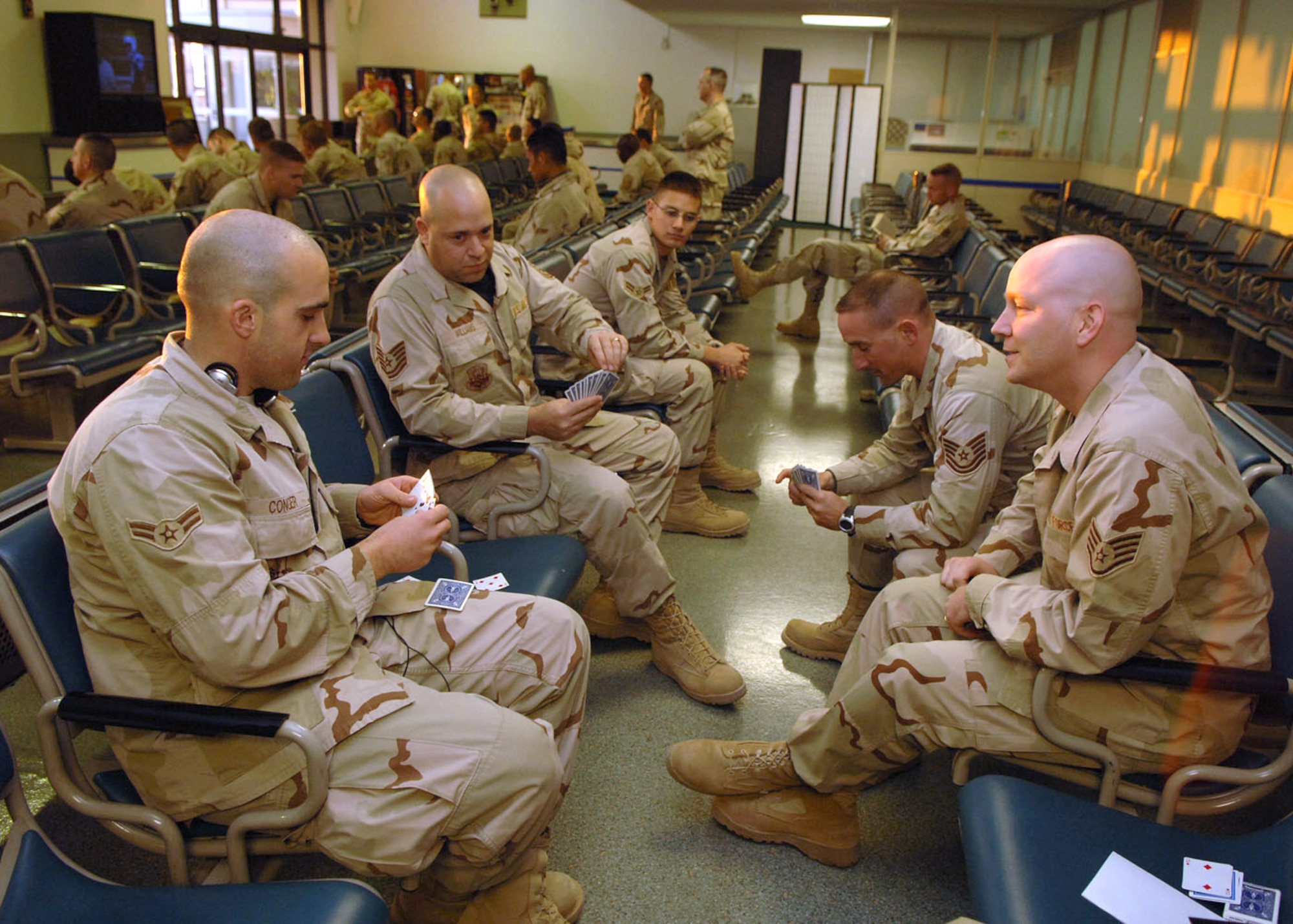 (From left) Airman 1st Class Thomas Conger, Tech. Sgt. Steve Williams, Tech. Sgt. Thomas Badgero and Staff Sgt. Corey Proulx play a card game at the Yokota Air Base, Japan, passenger terminal Jan. 23 while waiting for a flight to return home after a deployment to the Middle East. The Airmen are assigned to the 354th Logistics Readiness Squadron at Eielson Air Force Base, Alaska. (U.S. Air Force photo/Senior Airman Veronica Pierce)