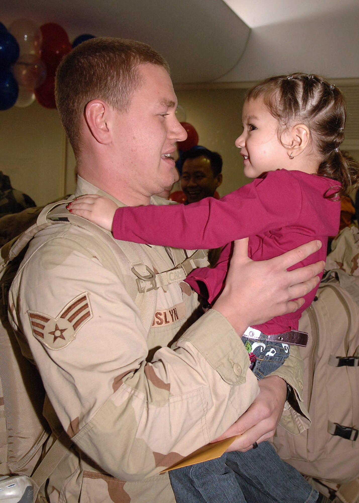 Senior Airman Josh Joslyn reunites with his daughter, Jasmine Joslyn, after his deployment from Operation Iraqi Freedom Jan. 23 at Yokota Air Base, Japan. Airman Joslyn is assigned 374th Logistic Readiness Squadron. (U.S. Air Force photo/Senior Airman Veronica Pierce)