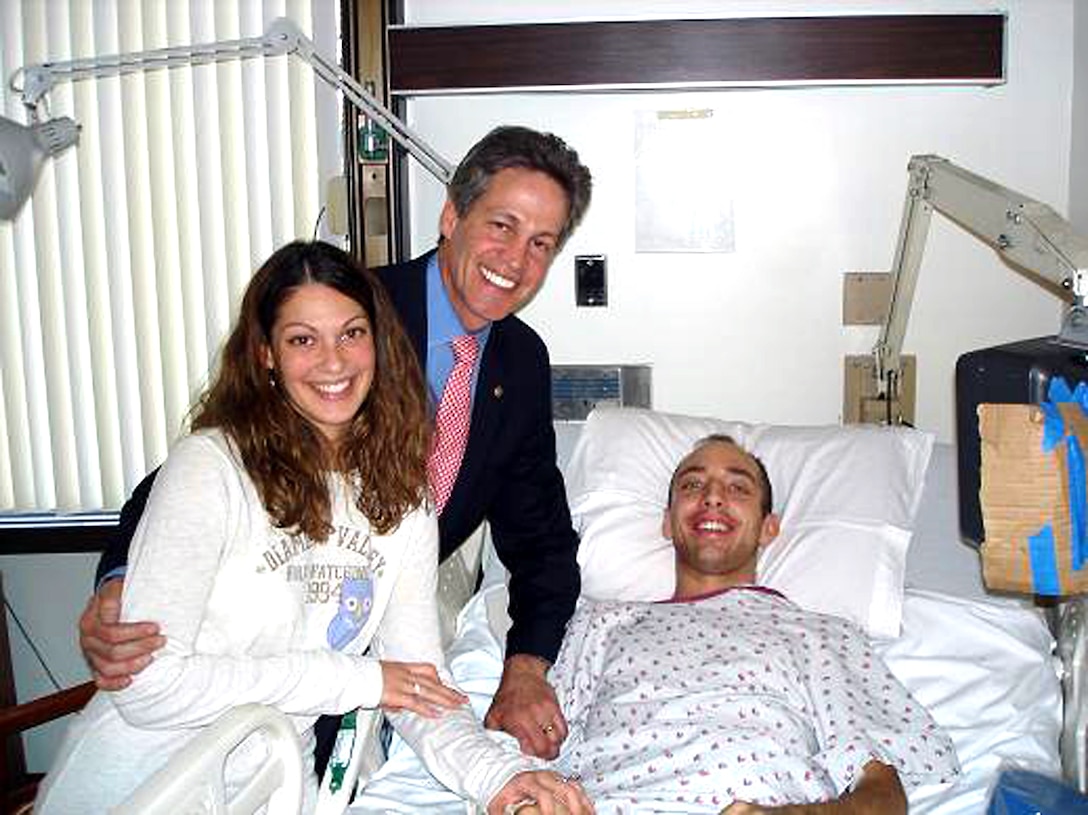 Minnesota Army National Guard Sgt. John Kriesel and his wife, Katie, get a visit from Minnesota U.S. Sen. Norm Coleman (center). John is recuperating at Walter Reed Army Medical Center in Washington after being hit by a roadside bomb Dec. 2 while serving in Fallujah, Iraq. Courtesy photo