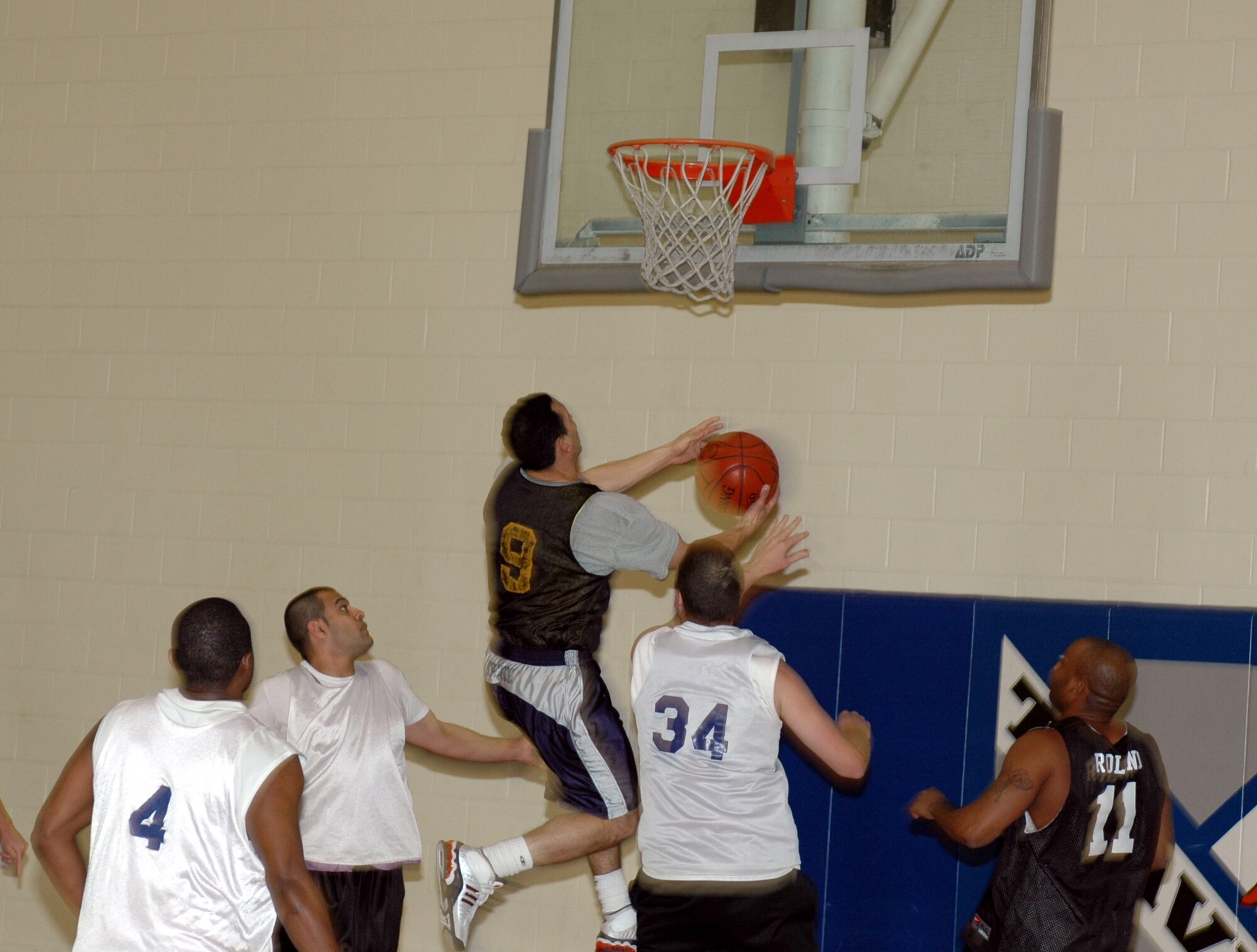 Justin Giovannettone, G-Unit point guard, goes airborne as he attempts an acrobatic layup during his team’s game against the 60th Services Squadron Monday. After being down by ten points with 10 minutes to play, Giovannettone led his team on a 14-4 run to take a 41-40 lead with four minutes to play. The 60th SVS eventually won the game 47-43. (U.S. Air Force photo by Staff Sgt. Candy Knight)