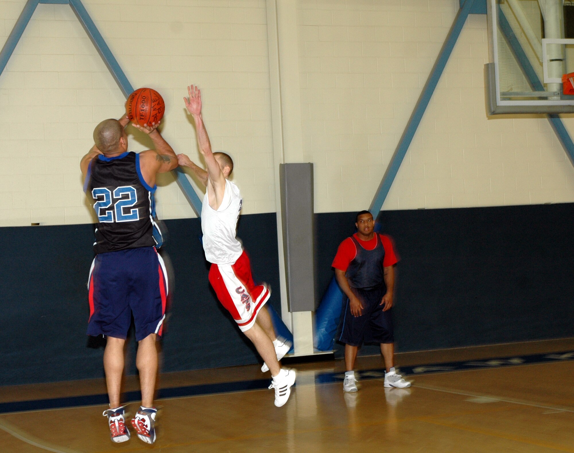 Mark Esquer, (#22), G-Unit small forward, attempts a three-point shot over Kyle Krieman, 60th Services Squadron small forward, during their game Jan. 22. The 60th SVS won 47-43. (U.S. Air Force photo by Staff Sgt. Candy Knight)