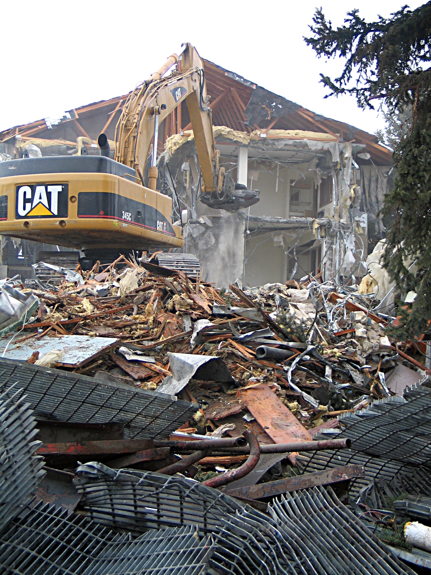 Building 623, at the corner of Bong St. and Chennault, crashes to the ground Tuesday. Innovative Technical Solutions, Inc., crews are in the process of tearing down this building and bldg. 622, as they don?t meet Air Force standards. Between now and the scheduled completion in March, the contracting company will oversee teardown, underground piping excavation, ground tilling and sculpting for proper drainage, and ground seeding. (U.S. Air Force photo by Staff Sgt. Connie L. Bias)