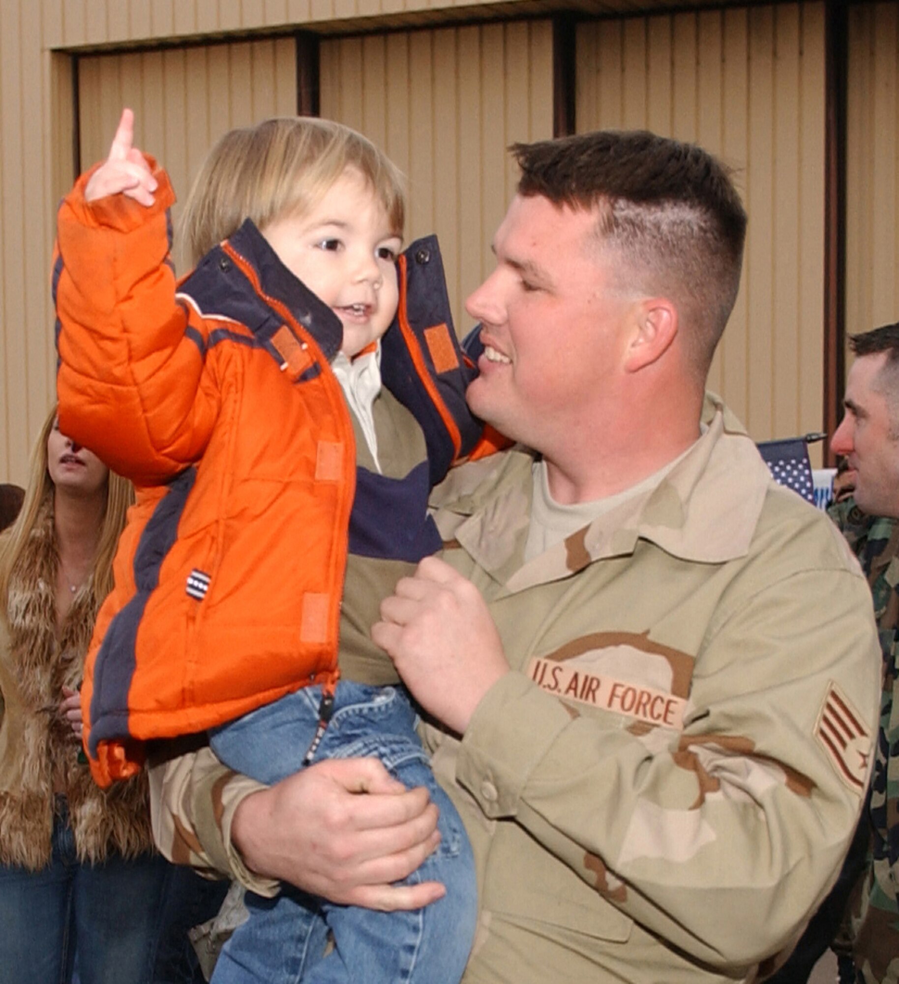 Staff Sgt. Nicholas Asbury, 27th Equipment Maintenance Squadron, holds his son at the flightline shortly after returning to Cannon Air Force Base, N.M. via a chartered jet Jan. 18. Sergeant Asbury was one of nearly 300 Airmen who returned on the flight after serving in Iraq for four months. (Air Force photo/Tech. Sgt. Scott McKay) 