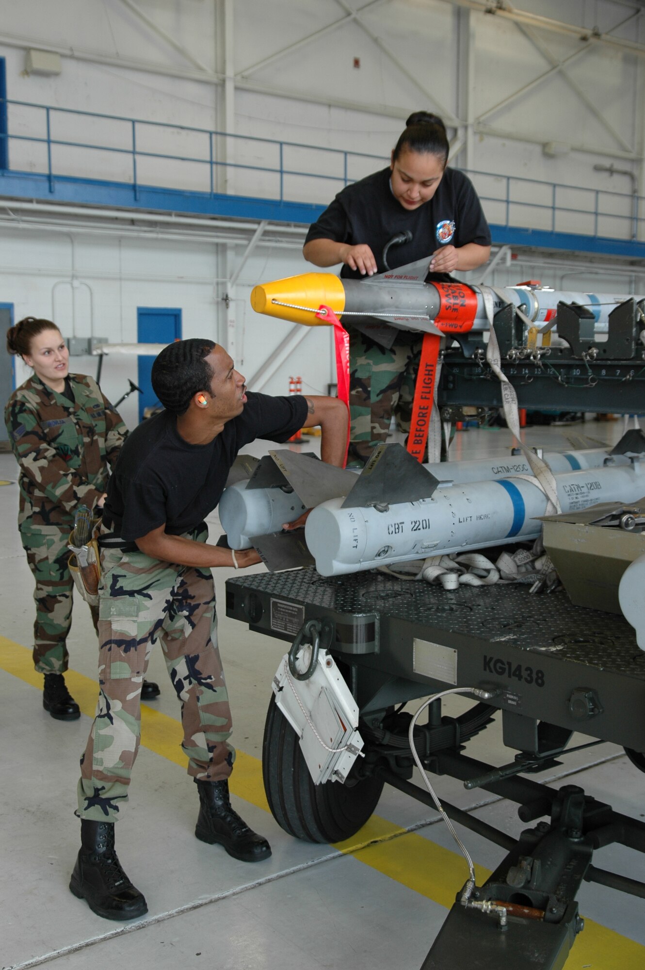 EGLIN AIR FORCE BASE, Fla. – Staff Sgt. Keith Bowie and Sr. Airman Candy Thompson, 58th Aircraft Maintenance Unit load crew members inspect and install fins on the AIM-120 AMRAM and AIM-9X as Sr. Airman Jessalyn Borja, 33d Maintenance Group evaluates during the 33d Fighter Wing’s annual load crew competition Jan. 19.  The annual load competition is a contest to determine which AMU has the best weapons load team.  Winners are scheduled to be announced Feb. 9. (Air Force Photo/by Capt. Brooke Brander)