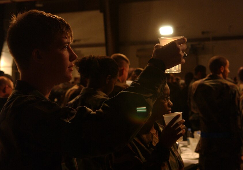 OSAN AIR BASE, Republic of Korea --  The Osan 5/6 Club hosted the first Team Osan 'Enlisted Only' Combat Dining-In Nov. 30 at the traffic management office warehouse in Bldg 635.Airman Tyler Haile, 51st Communications Squadron, raises his glass during the silent toast to all POW/MIAs. The toast was done with water to symbolize the fact that it was the only thing POWs had to drink. (U.S. Air Force photo by Staff Sgt. Chrissy Fitzgerald)