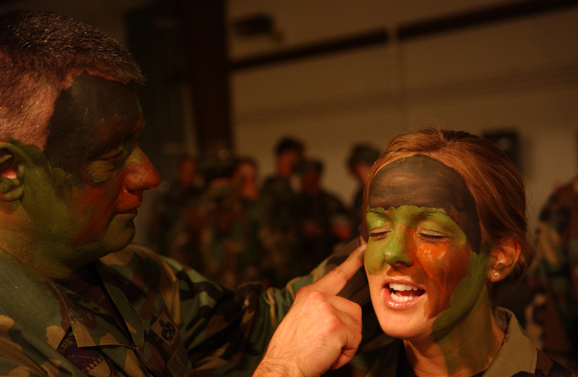 OSAN AIR BASE, Republic of Korea -- Senior Master Sgt. Charles Willis helps Senior Airman Katie Sullivan, both 51st Maintenance Squadron, get her “game face” on so she matches the rest of her office. The Osan 5/6 Club hosted the first Team Osan 'Enlisted Only' Combat Dining-In Nov. 30 at the traffic management office warehouse in Bldg 635. (U.S. Air Force photo by Staff Sgt. Chrissy Fitzgerald)