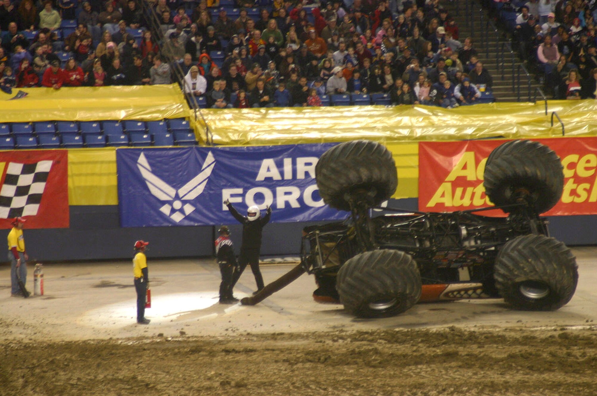 Monster Mutt driver Bobby Z emerges from his overturned 1951 Mercury shelled monster truck and poses with thumbs up in front of the Air Force banner at the Tacoma Dome Jan. 12 in Tacoma, Wash. The driver couldn't keep the 66-inch tires under the precious pooch while navigating a sharp turn in the freestyle competition of the event.  Recruiters from the 361st Recruiting Squadron were on hand over the weekend passing out Air Force literature and promotion items and answering questions to those enquiring more on life in the Air Force.  (U.S. Air Force photo by Tech. Sgt. Chuck Marsh)