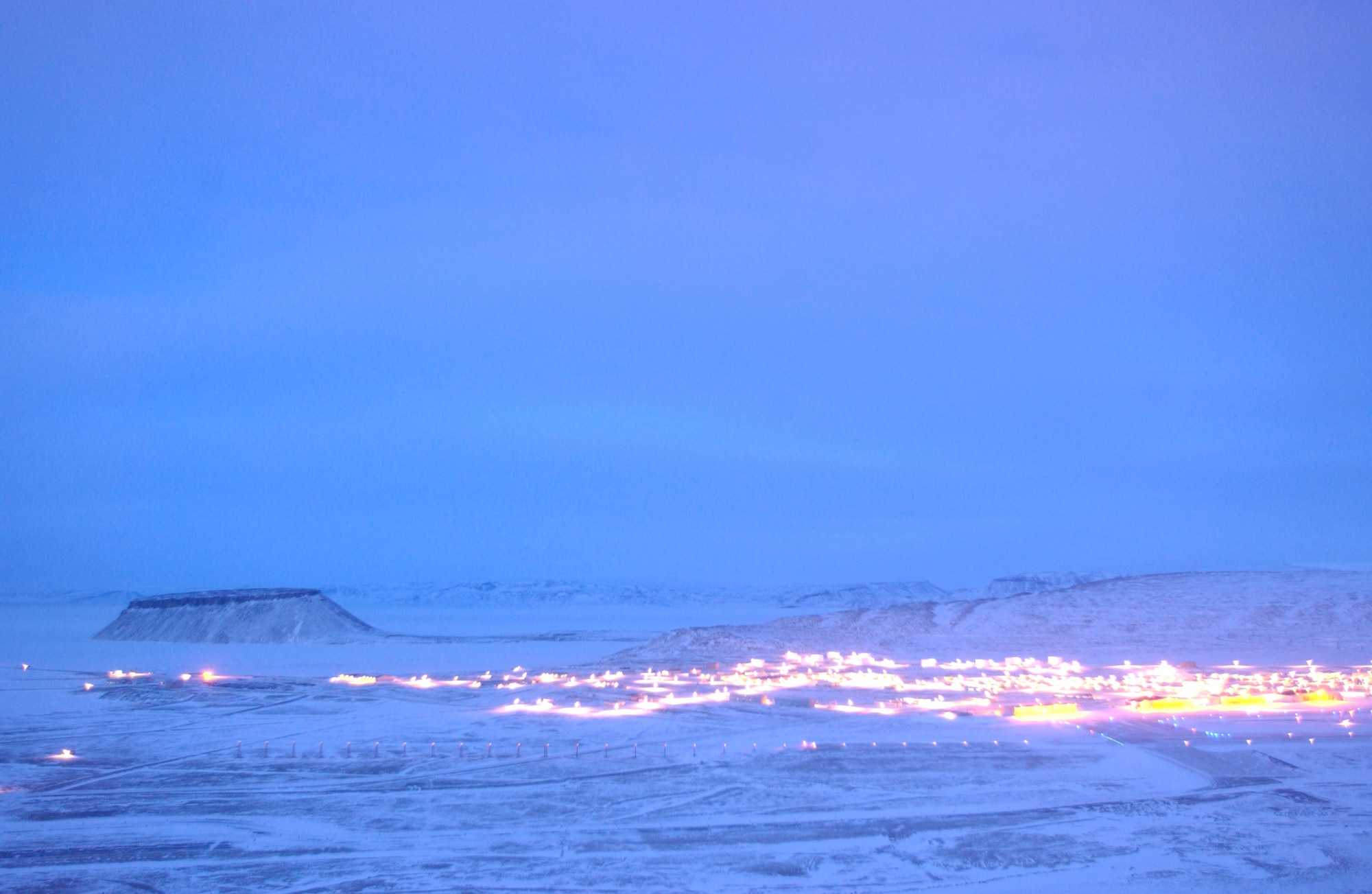 From South Mountain, Thule Air Base and Mount Dundas are captured during a short period of January twilight using time-lapsed photography to show the minimal amount of available light Jan. 25 in Greenland. Airmen serve a one-year remote, unaccompanied tour here in a multinational environment. (U.S. Air Force photo/Michael Tolzmann) 
