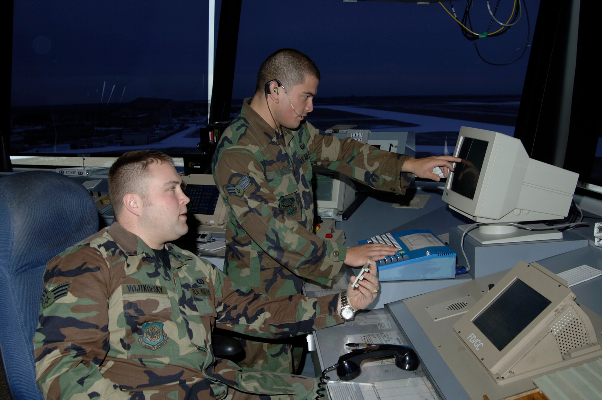 Senior Airman Robert Vojtkofsky, left, and Senior Airman Briant Bell, both 22nd Operation Support Squadron air traffic controllers, work the air traffic control tower Jan. 18. Air traffic controllers here monitor aircraft in order to prevent accidents. They direct the movement of aircraft into and out of McConnell’s airfield. They track aircraft by radar and relay information to aircrews via radio. They relay flight and landing instructions, weather reports and safety information to pilots.  