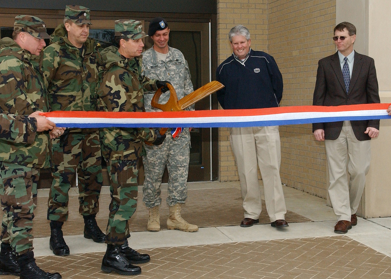 Brig. Gen. Darrell Jones, then the 37th Training Wing commander at Lackland Air Force Base, Texas, prepares to cut a ribbon Jan. 22, 2007, to dedicate a new 300-room, 600-man dormitory for 343rd Training Squadron security forces students. With the general, from left, are Col. Eric Beene, commander of the 37th Mission Support Group; Lt. Col. Mike Kelly, deputy commander of the 37th Training Group; Maj. Ray Walser, Lackland resident engineer for the Army Corps of Engineers; Tim Chadwick, president of MW Builders of Texas Inc.; and John Heye, deputy civil engineer for the 37th Civil Engineer Squadron. MW Builders constructed the dorm at the north end of Carswell Avenue, along with a new dining facility that opened Jan. 3 on Lackland Training Annex, under a single $33.4 million military construction contract. (USAF photo by Alan Boedeker)                               