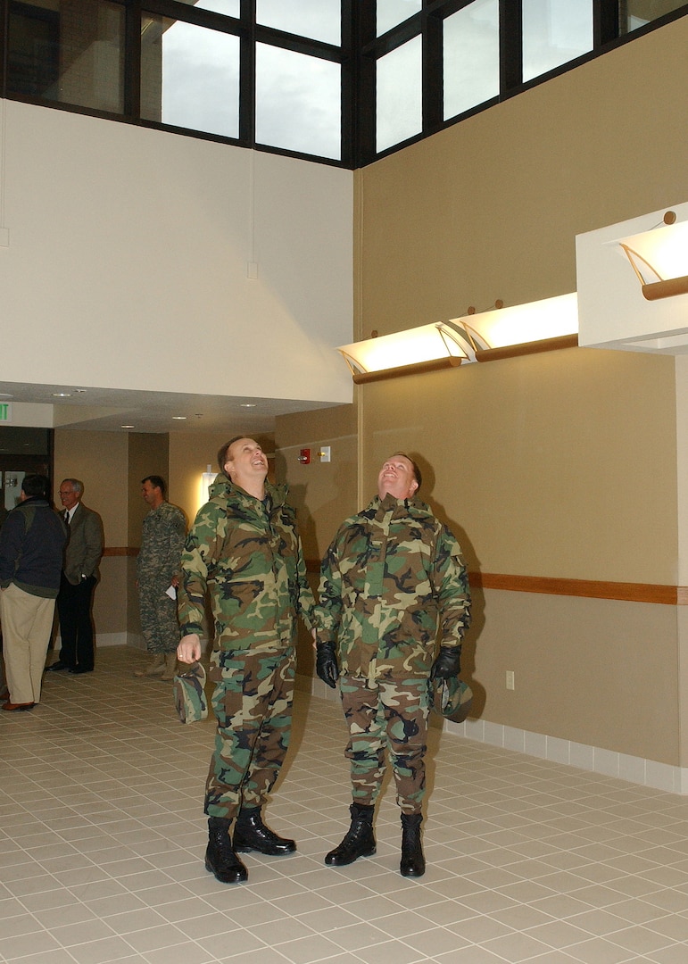 Lt. Col. Mike Kelly (left), deputy commander of the 37th Training Group at Lackland Air Force Base, Texas, and Col. Eric Beene, commander of the 37th Mission Support Group, look up and admire the atrium view from the ground floor of a new three-story dormitory for 600 security forces students during a walk-through following the building dedication Jan. 24. (USAF photo by Alan Boedeker)                               