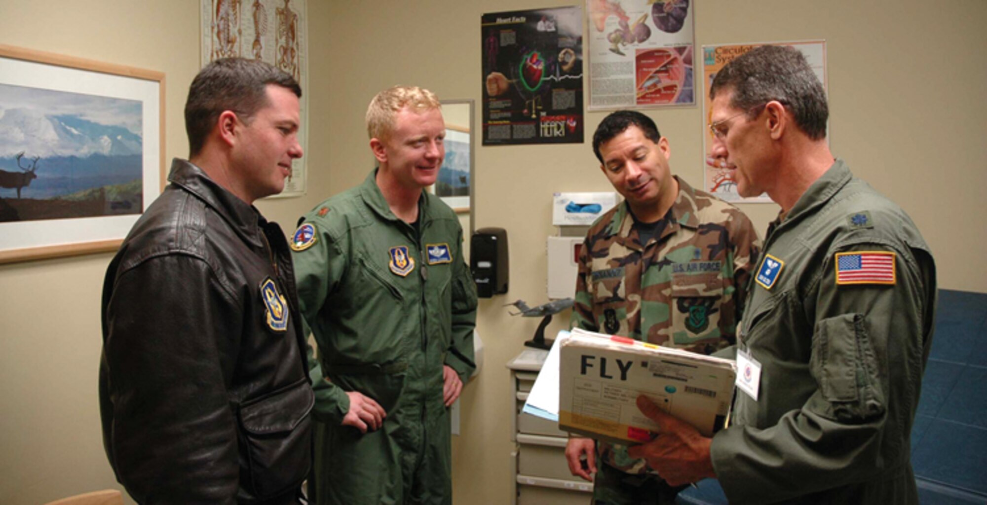 From left to right, 97th Airlift Squadron pilots Capt. Rob Selmer and Maj. Derek Leckrone discuss flight health safety issues with Chief Master Sgt. Minett Fernandez 446th Aerospace Medicine Squadron superintendent and flight surgeon Lt. Col. (Dr.) John Golden. 