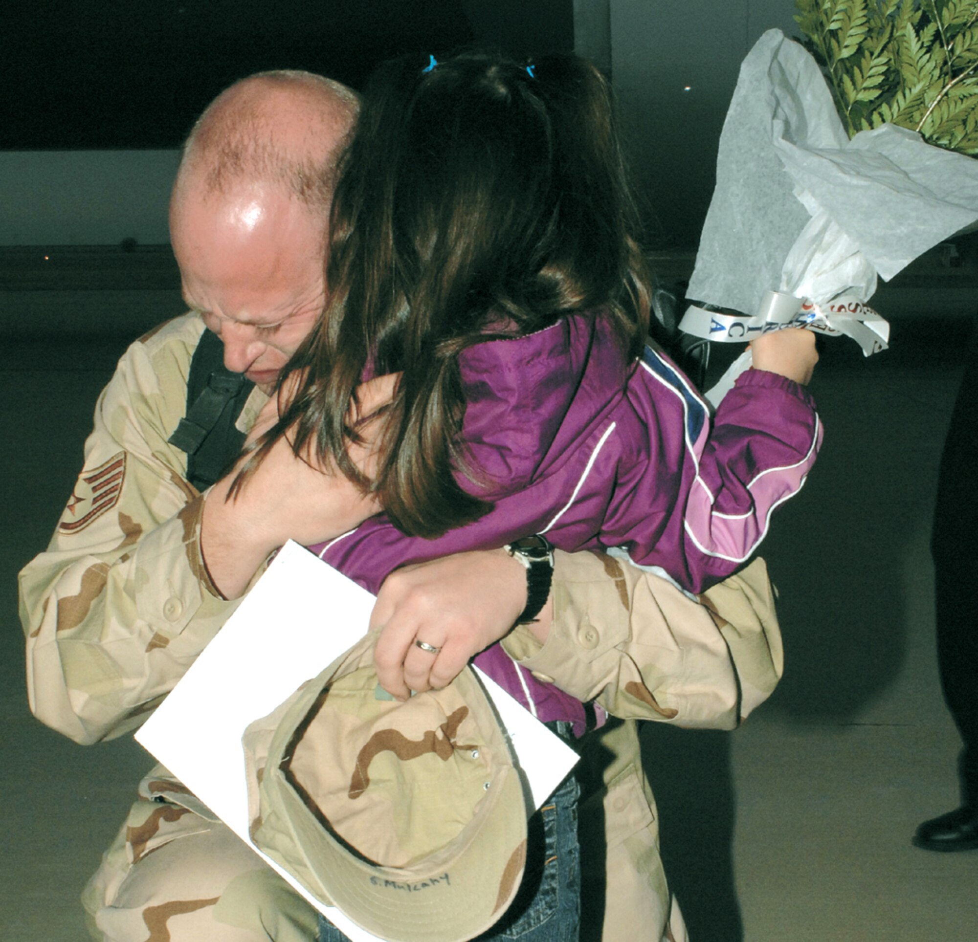 Staff Sgt. Sean Mulcahey, 27th Aircraft Maintenance Squadron, embraces his daughter,Sabrina, Jan. 18, after returning from a four-month deployment to Balad Air Base, Iraq. Sergeant Mulcahey was one of nearly 300 Airmen greeted by families, friends and co-workers at Hangar 133, Cannon Air Force Base, N.M. (Air Force photo/ Airman 1st Class Randi Flaugh)