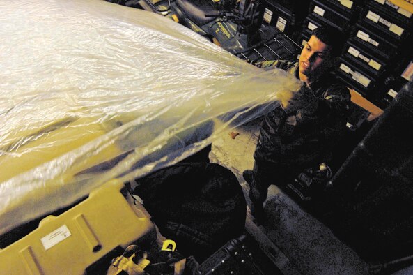 SHAW AIR FORCE BASE, S.C. -- Airman 1st Class Lucas Smith, 20th Communications Squadron, covers cargo Jan. 22 during the pallet build-up portion of the Phase I exercise, Sea Lion 07-03. Phase I exercises test the wing’s ability to demonstrate combat capability. The primary objective of January's Phase I exercise was to successfully generate 24 combat aircraft, associated equipment and personnel safely and on time, according to exercise planners. (U.S. Air Force photo/Tech. Sgt. Keri Whitehead)
