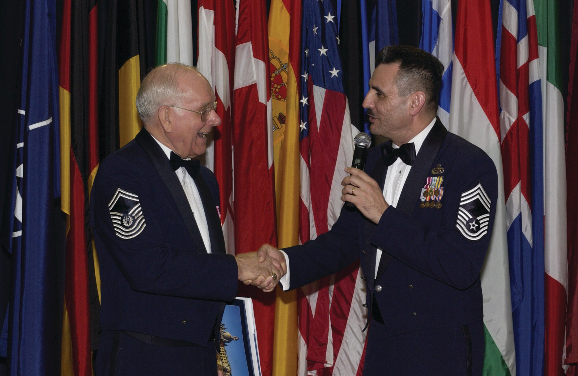 Chief Master Sgt. Marc Rodriguez, 52nd Mission Support Group, right, shakes hands with retired Chief Master Sergeant of the Air Force Sam Parish during a Chief’s Recognition Ceremony at Club Eifel Saturday. (US Air Force photo by Senior Airman Kristin Ruleau)
