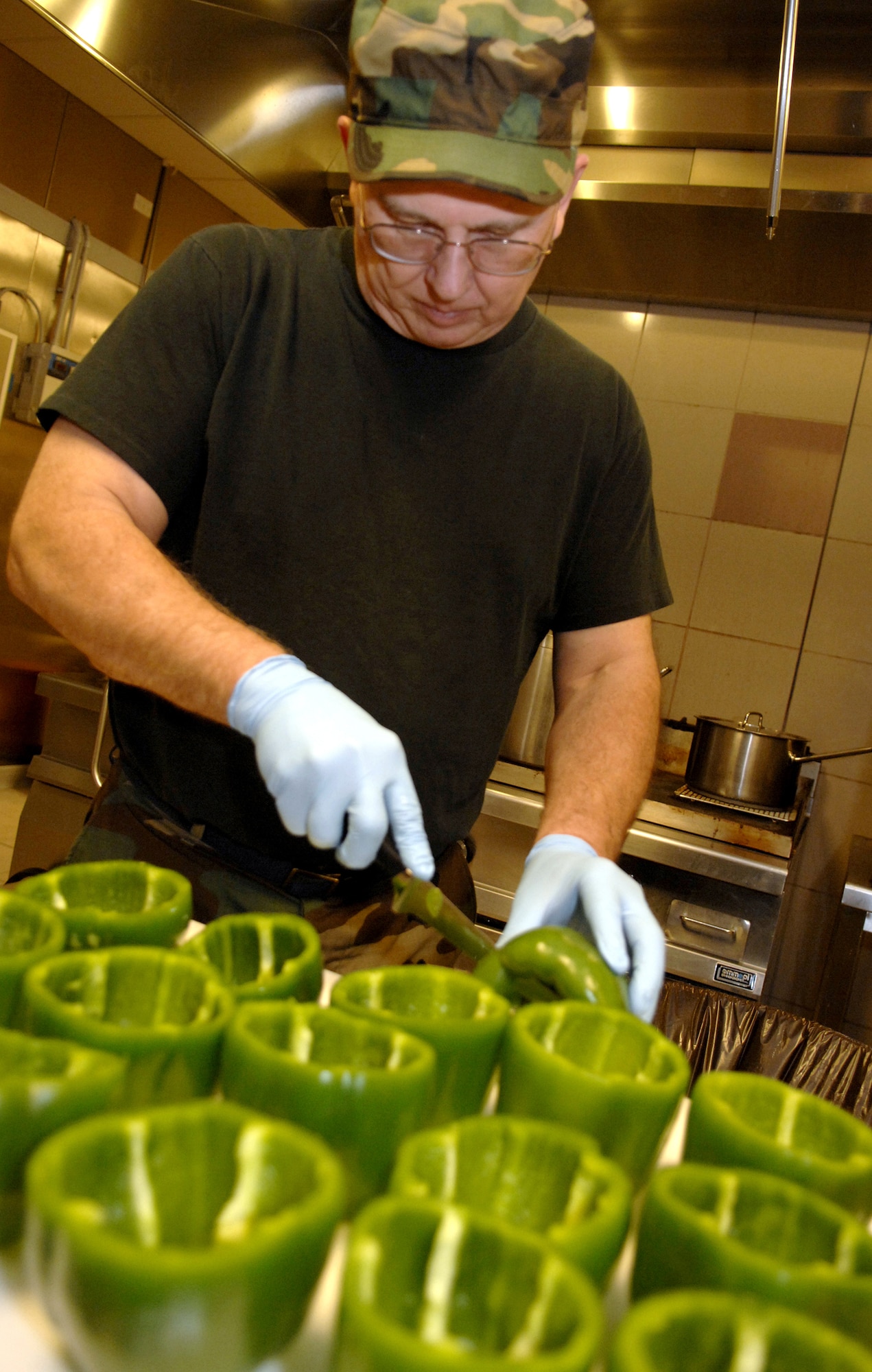 Staff Sgt. Bob Starkey, 120th Fighter Wing food service craftsman, cuts bell peppers in preparation for dinner at the La Dolce Vita Dining Facility. Sergeant Starkey is an Air National Guardsman deployed from Great Falls, Montana. Five members of the Air National Guard are working in the La Dolce Vita as part of their annual two-week duty.  (Photo by Airman 1st Class Michael Dorus)