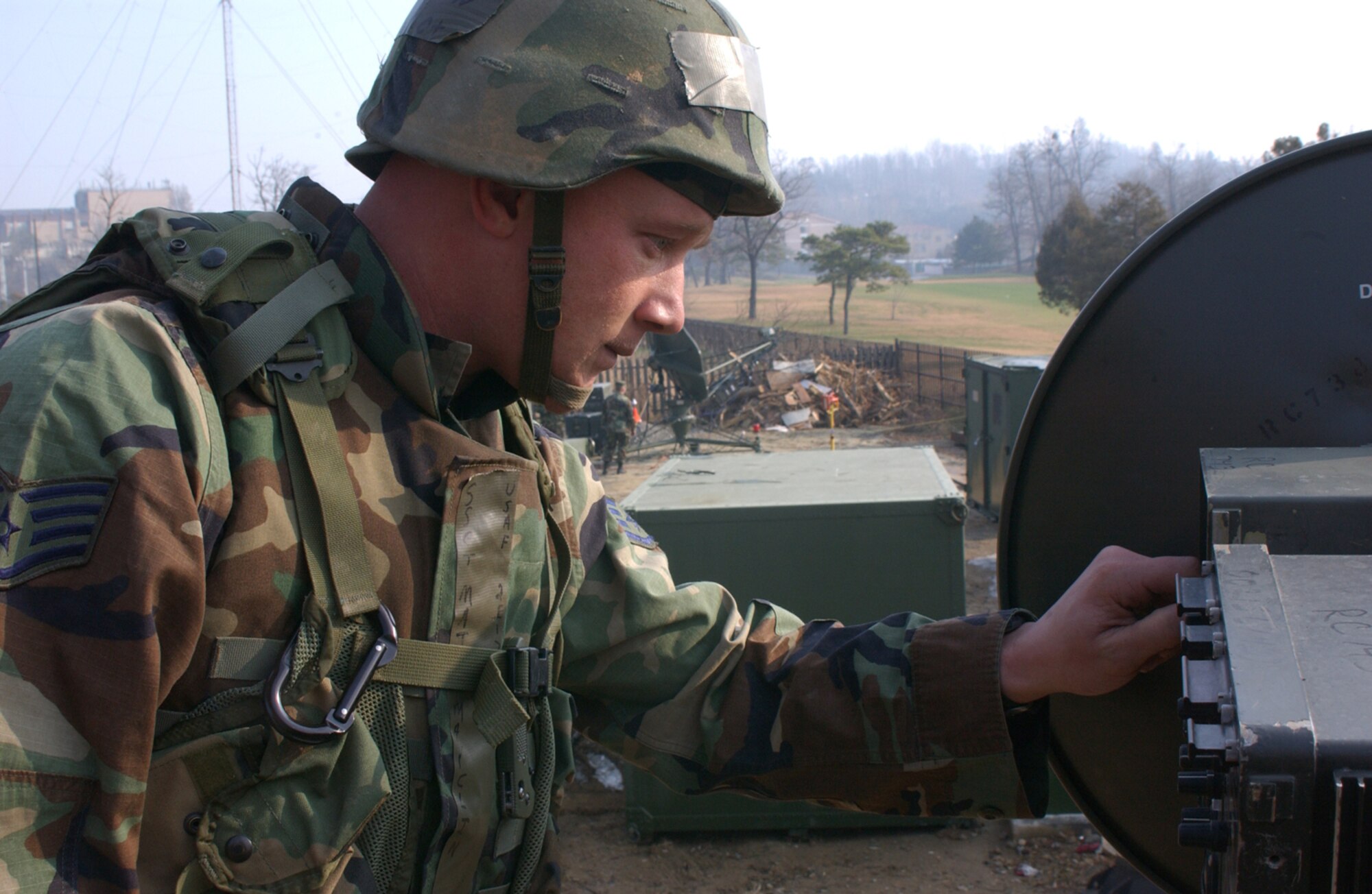 OSAN AIR BASE, Republic of Korea --  Staff Sgt. Matt Mayclin, 607th Combat Communications Squadron, adjusts one of the satellites at the deployed tactical satellite shop. The satellite is responsible for relaying information to and from the HTACC. (U.S. Air Force photo by Senior Airman Eunique Stevens)