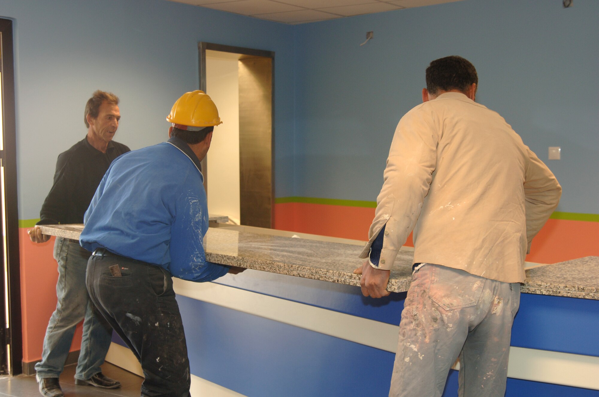 Members of Incirlik's Vinell Brown and Root install a new marble counter top for the refreshment counter in the base theater. The theater started it's renovations in November and is scheduled to re-open Jan 27. (U.S. Air Force photo by Airman 1st Class Kelly LeGuillon)