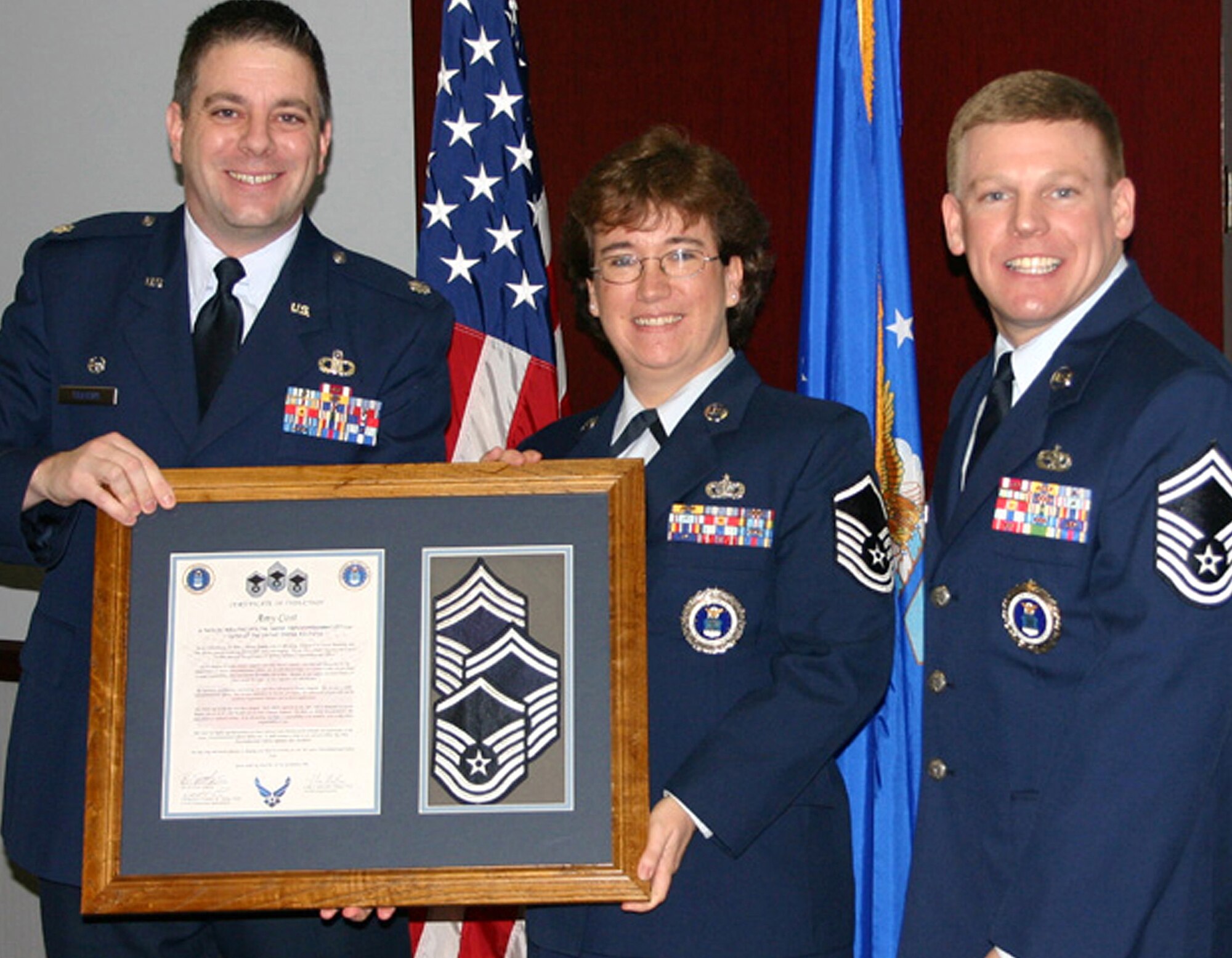 Master Sgt. Amy Cost, 330th Recruiting Squadron marketing representative, accepts a gift welcoming her into the Air Force Top Three following her promotion to E-7 under the Stripes for Exceptional Performers program. Presenting the award are Lt. Col. Robert W. Trayers Jr., left, 330th RCS commander, and Senior Master Sgt. Charles E. Lamer Jr., squadron production superintendent and Sergeant Cost’s supervisor. The STEP program is reserved for staff to master sergeants who have performed exceptionally well during their careers and are selected for promotion by their commander. (Courtesy photo by Terry Meyer)