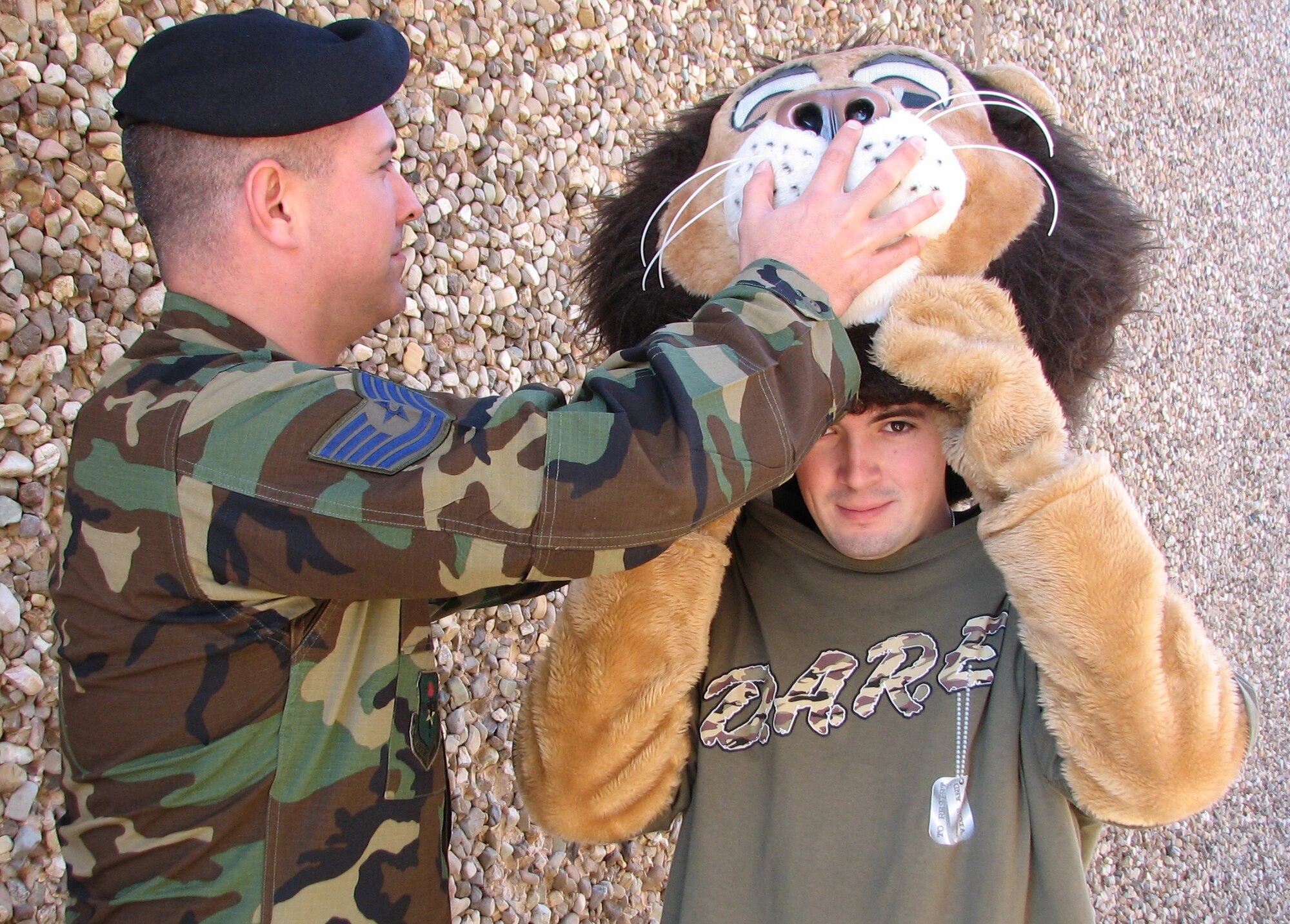 Tech.Sgt. Robert Novak helps 2nd. Lt. Leonard Sly into his Darren the DARE lion costume as the two 71st Security Forces Squadron members prepare for one of the 11 DARE graduation ceremonies supported by Team Vance at Enid’s elementary schools. (Photo by Frank McIntyre)