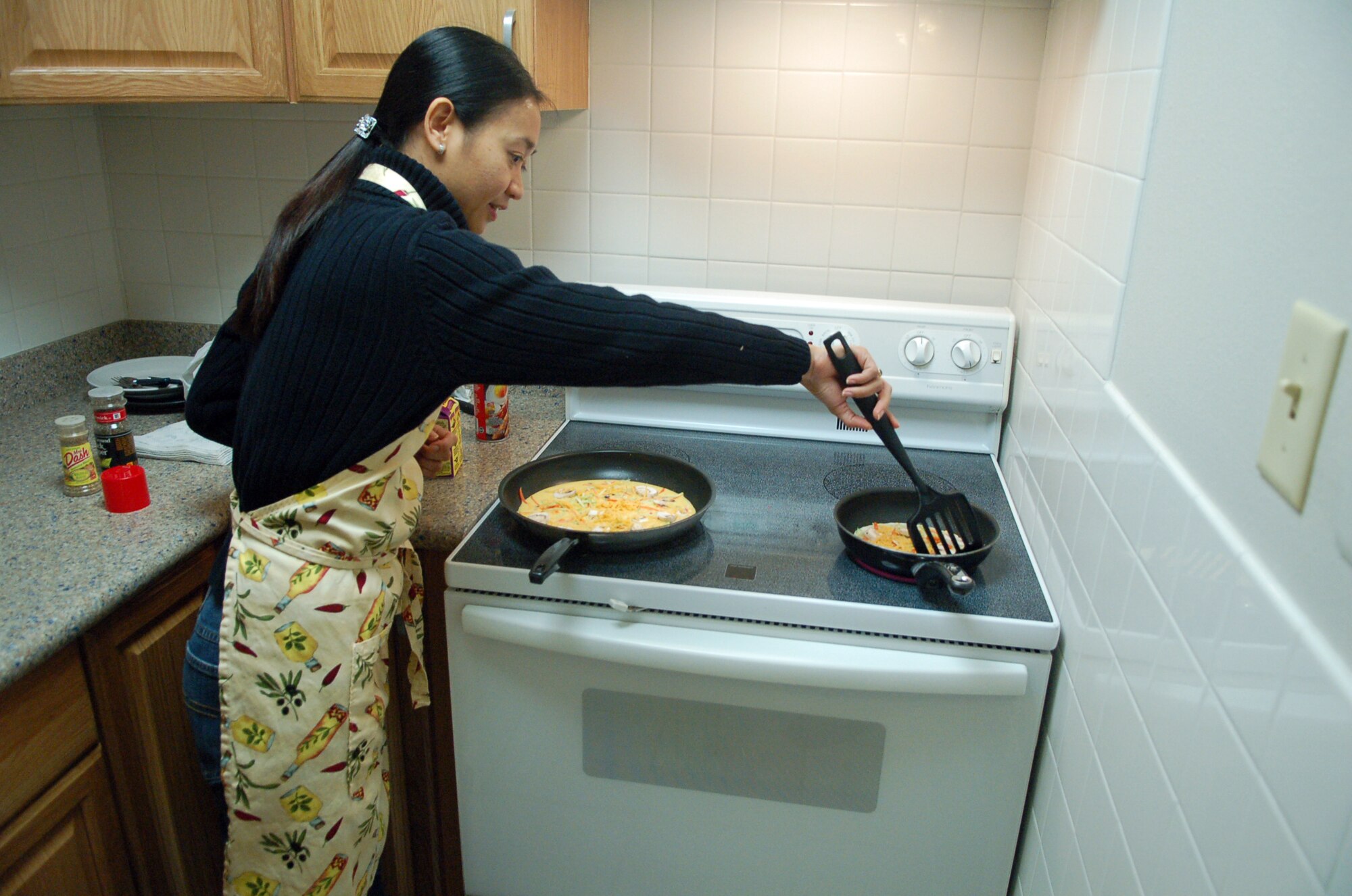LAUGHLIN AIR FORCE BASE, Texas -- Kumang Goins, Laughlin Health and Wellness Center, demonstrates cooking a vegetable omelet for dorm residents in one of their three new kitchens Jan. 25.  (U.S. Air Force photo by Staff Sgt. Austin M. May)