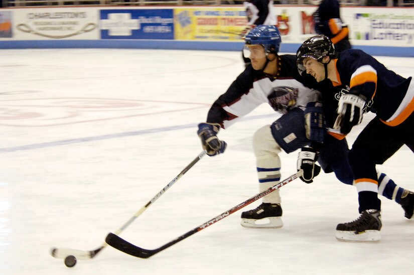 Christopher Pace, Air Force forward, battles for control of the puck with a Coast Guard player during the game. The Coast Guard beat the Air Force team 6-3, however, Air Force qualified for the Stingrays Military Cup to be held Feb. 17 at 3 p.m. at the North Charleston Coliseum against the Navy team. (U.S. Air Force photo by Staff Sgt. Ricky Bloom)