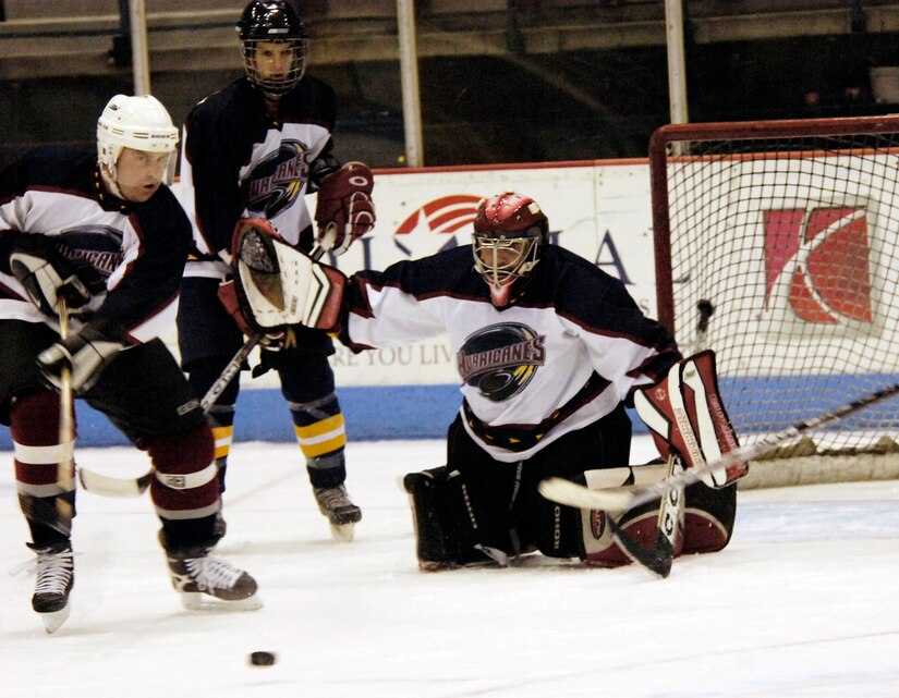 Raymond Girouard, forward, clears the puck as goalie Chris Prestero gaurds the net. (U.S. Air Force photo by Staff Sgt. Ricky Bloom)