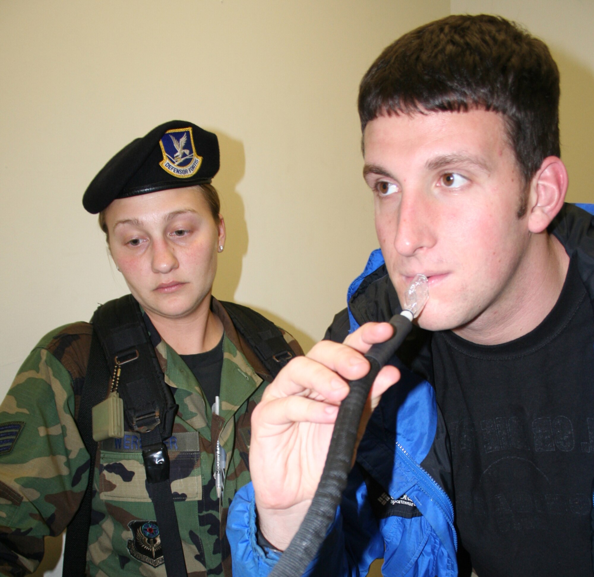 Staff Sgt. Esther Werstler, left, 1st Special Operations Security Forces Squadron, demonstrates how to administer a Breathalyzer test to Senior Airman Michael Levine, 1st SOSFS. (U.S. Air Force Photograph by Dylan Laurie)