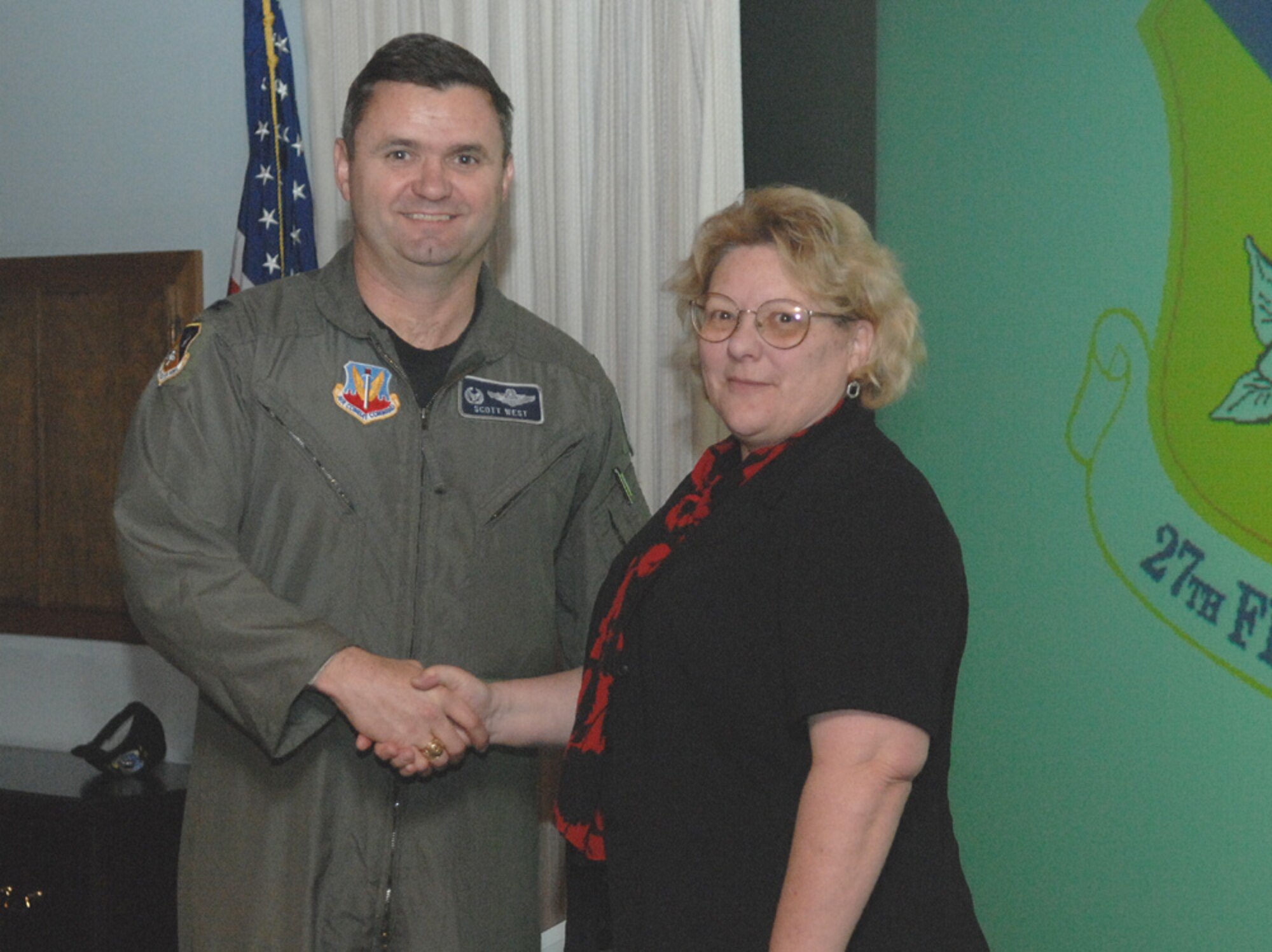 CANNON AIR FORCE BASE, N.M. -- Col. Scott West, 27th Fighter Wing commander, presents Ms. Oleary with the Viper Volunteer award Jan. 23. She earned this award by assisting with the maintenance group spouse’s day and volunteering as a sexual assault victim advocate. She knits booties for the Bundles for Babies program while lending a hand to downtown organizations. She has logged more than 100 hours coaching soccer and acted as the registrar for the men’s adult soccer league. (U.S. Air Force photo/Airman Erik Cardenas)