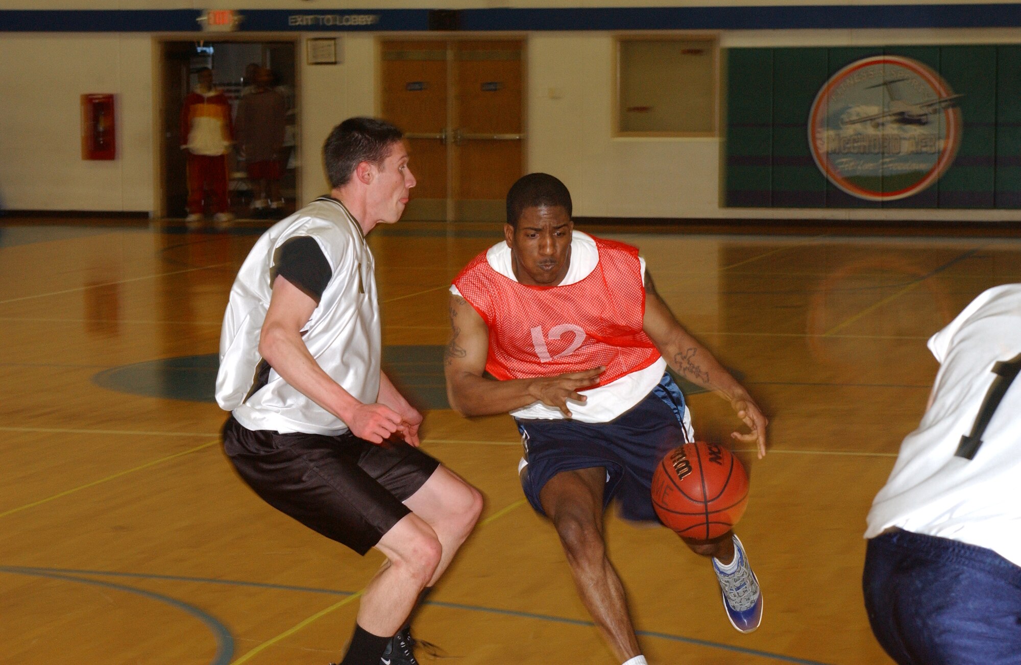MCCHORD AIR FORCE BASE, Wash.-- Reginald Harden, 62nd Aerial Port Squadron 2, drives to the hoop against Richard Robbins, Western Air Defense Sector. (U.S. Air Force Photo/Tyler Hemstreet)
