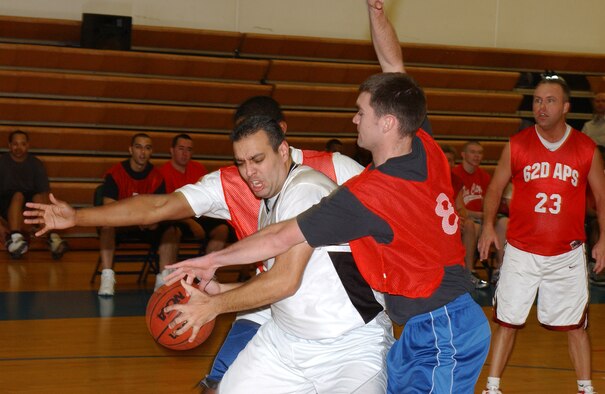 MCCHORD AIR FORCE BASE, Wash.-- Keith McDowell, Western Air Defense Sector, shields the ball from members of 62nd Aerial Port Squadron 2. (U.S. Air Force Photo/Tyler Hemstreet)
