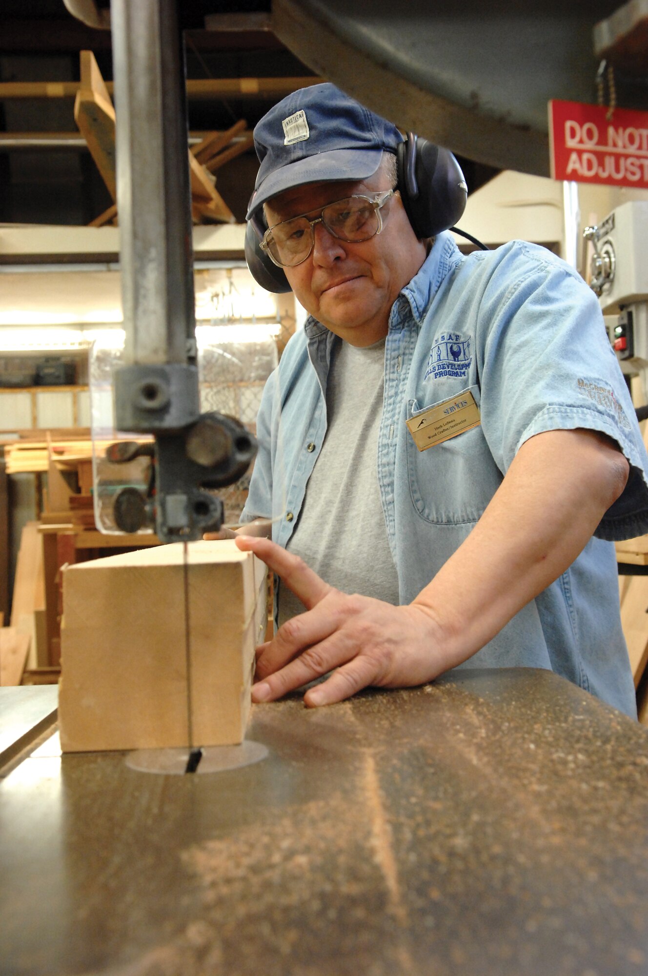 MCCHORD AIR FORCE BASE, Wash.-- Herb LeBeau,, 62nd Services Squadron woodworking instructor, prepares to slide a block of wood through a band saw in the arts and crafts woodworking area Jan. 18. (U.S. Air Force Photo/Abner Guzman)
