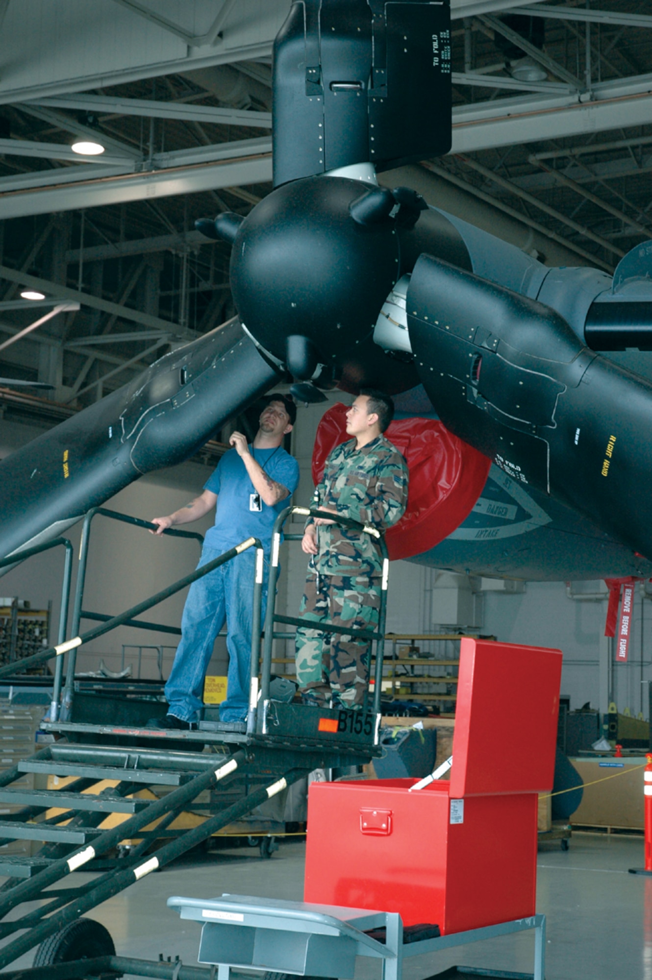 Crew chief Senior Airman Alexander Alonzo, 8th Aircraft Maintenance Unit, trains a contractor on blade components. The 8th AMU Airmen and contractors work side-by-side on the 8th Special Operations Squadron’s newest aircraft. (U.S. Air Force Photograph by Jamie Haig)