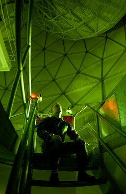 Tech. Sgt. Schubert observes a satellite dish inside one of the "golf ball" protective dish covers at Thule Air Base, Greenland as it rotates to track a satellite moving across the northern polar sky Jan. 25.  (U.S. Air Force photo/Michael Tolzmann)