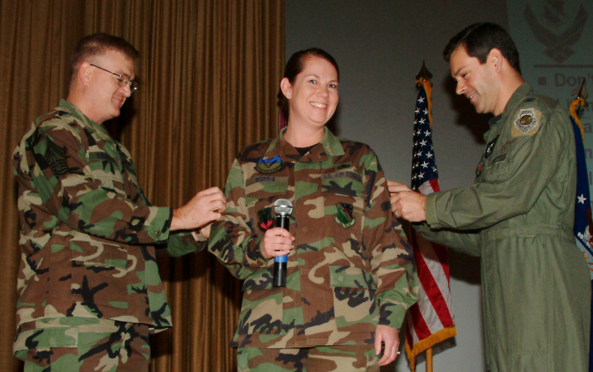 (Then) Tech. Sgt. Julie Morris, 16th Electronic Warfare Squadron, gets her new master sergeant stripes tacked on by Chief Master Sgt. Randy Salefske, 53d Wing command chief, and Col. Ken Wilsbach, wing commander, at a commander’s call Dec. 21. (Photo by Capt. Saje Park)
