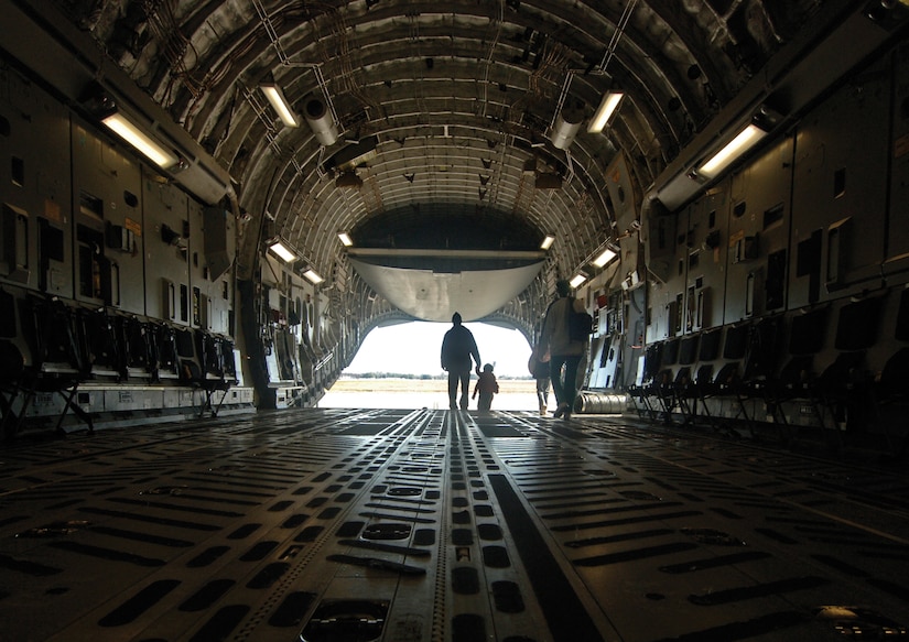 Sa'Michael Lopizich and his son, Sa’Michael Lopizich, exit the tail of a C-17 after the deployment. After processing through the deployment line, Team Charleston children were given a tour of a C-17. (U.S. Air Force photo/Staff Sgt. April Quintanilla)